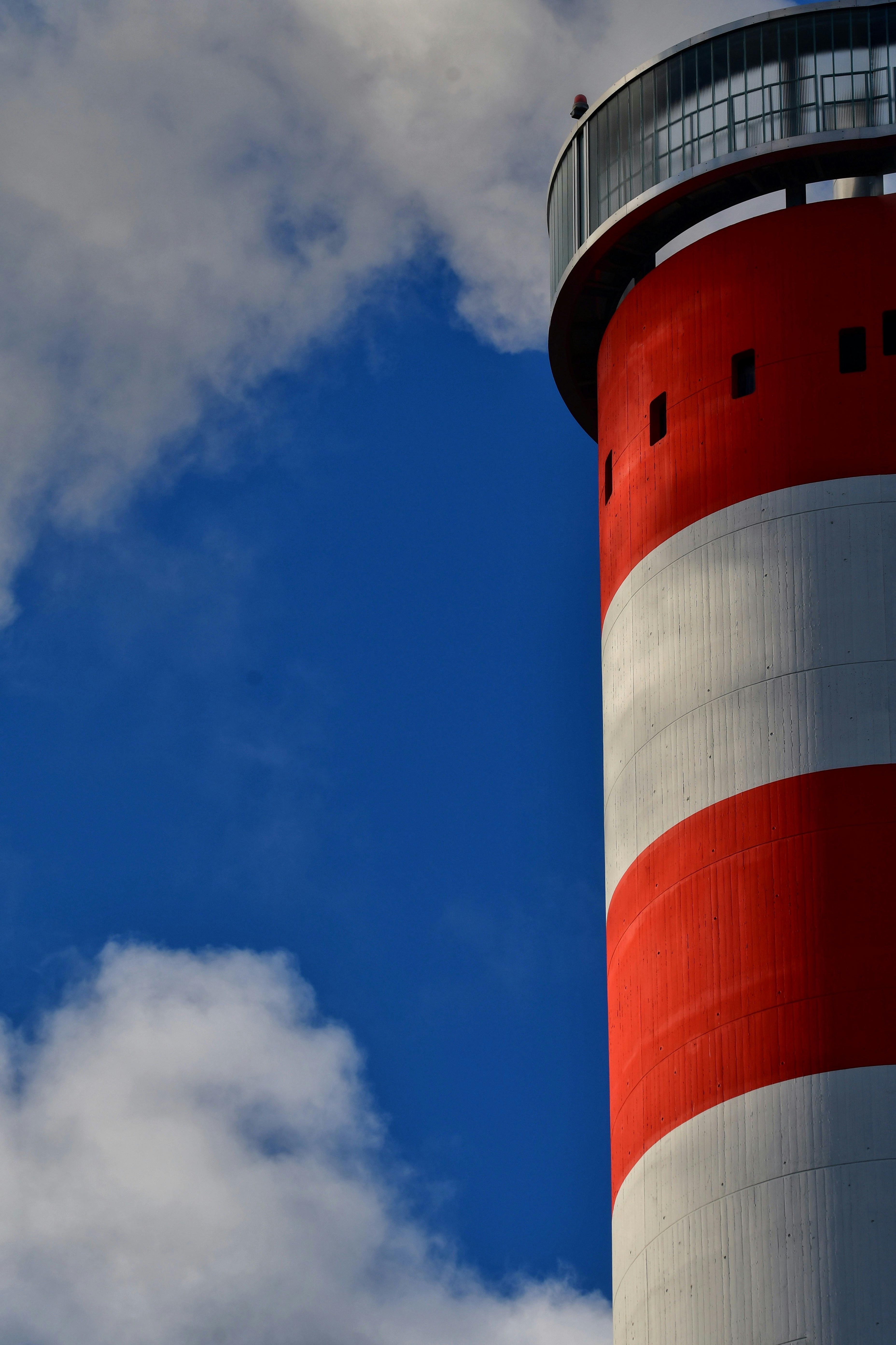 Red and white striped lighthouse against a blue sky