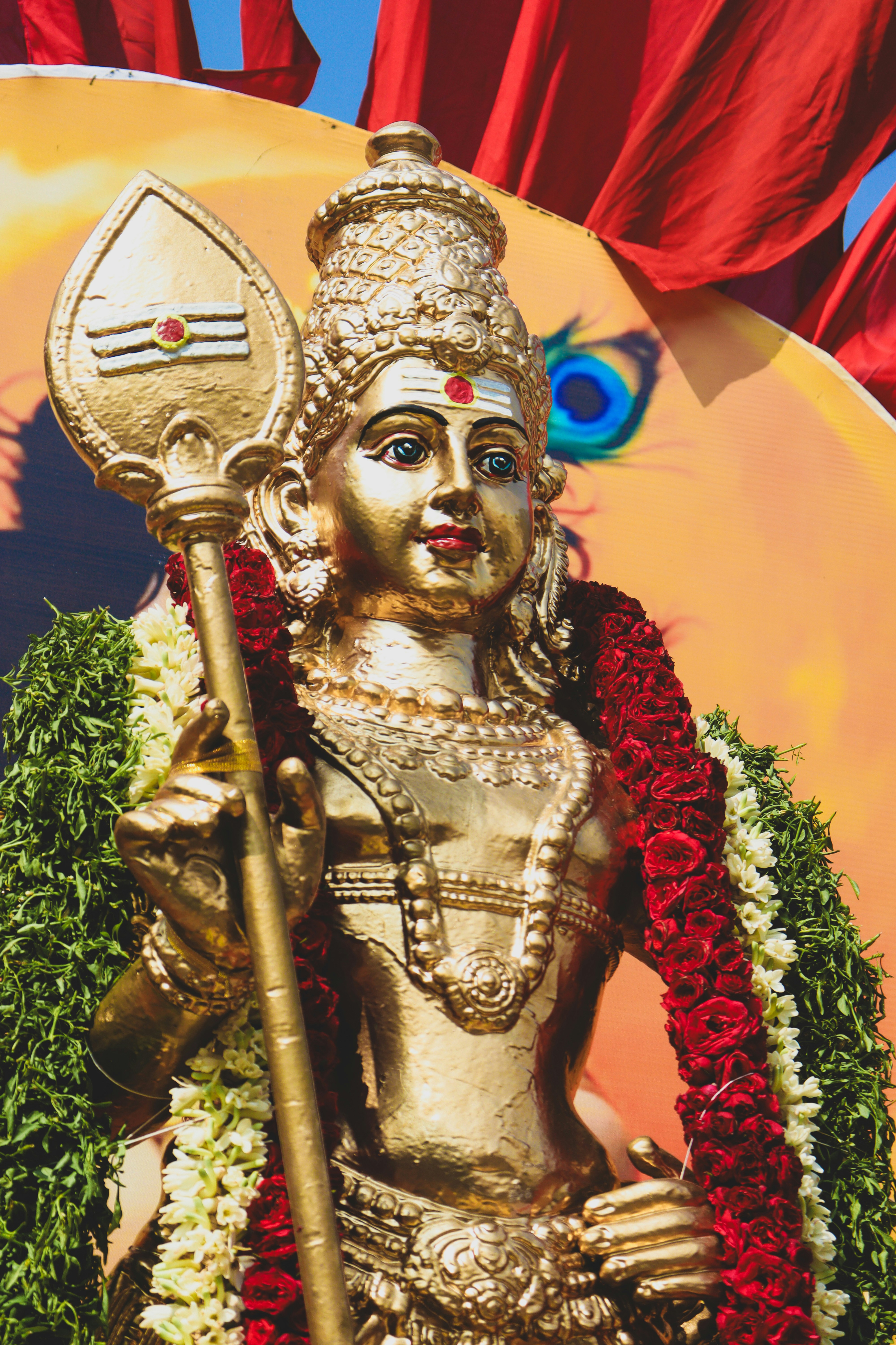 Goldene Statue einer hinduistischen Gottheit, die einen Speer hält