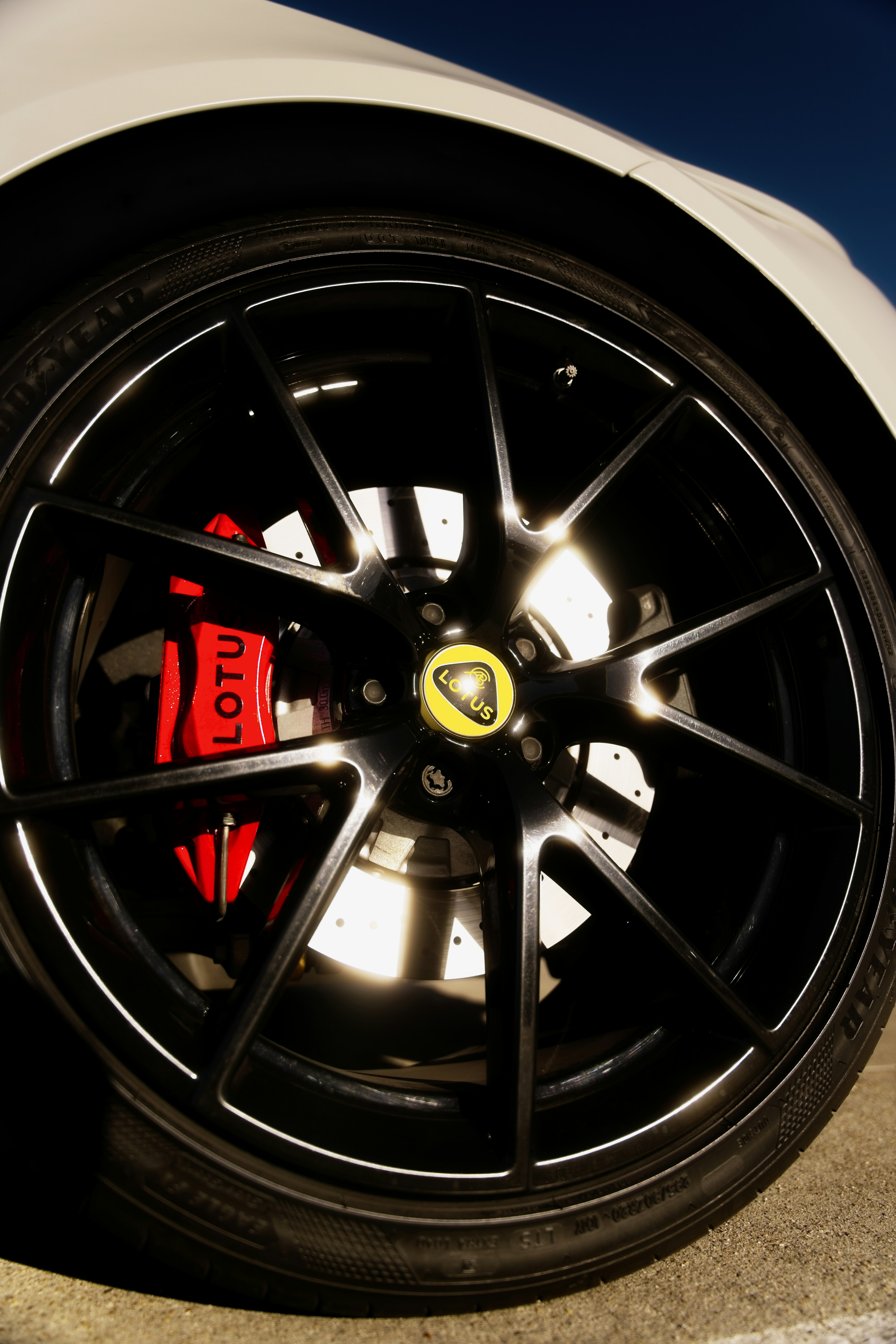 Close-up of a black alloy wheel with red brake caliper.