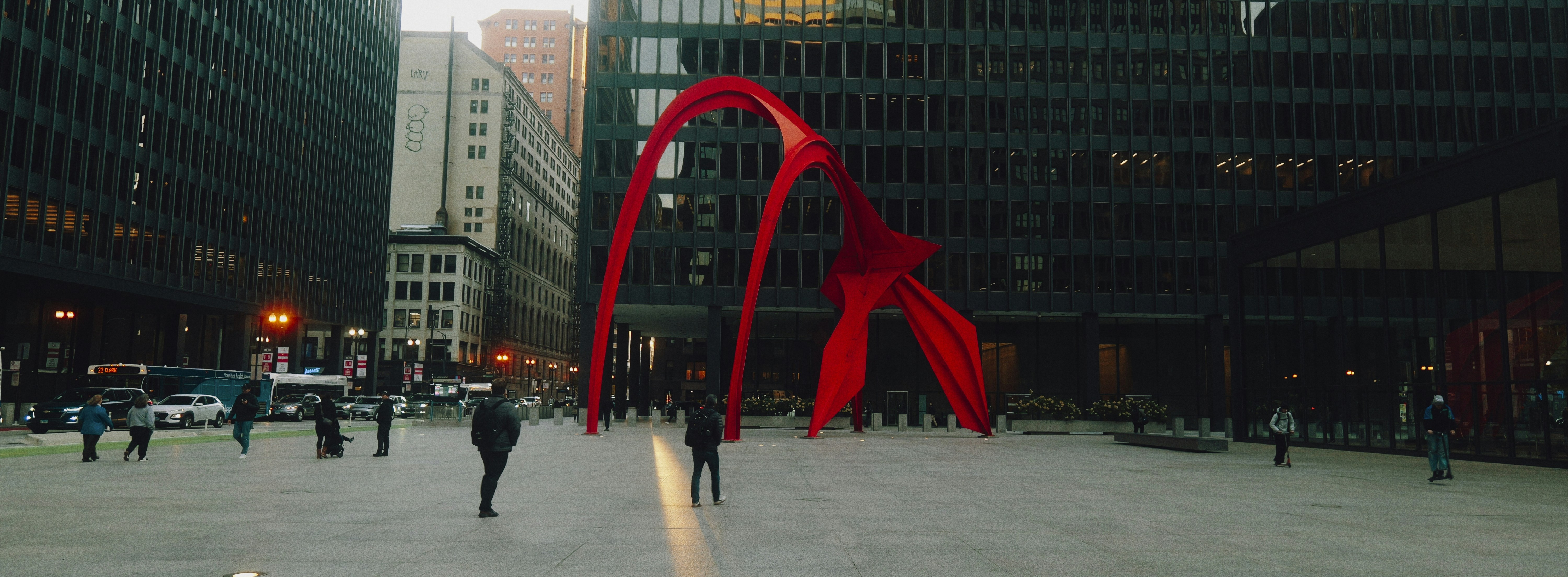 Red abstract sculpture in a city square