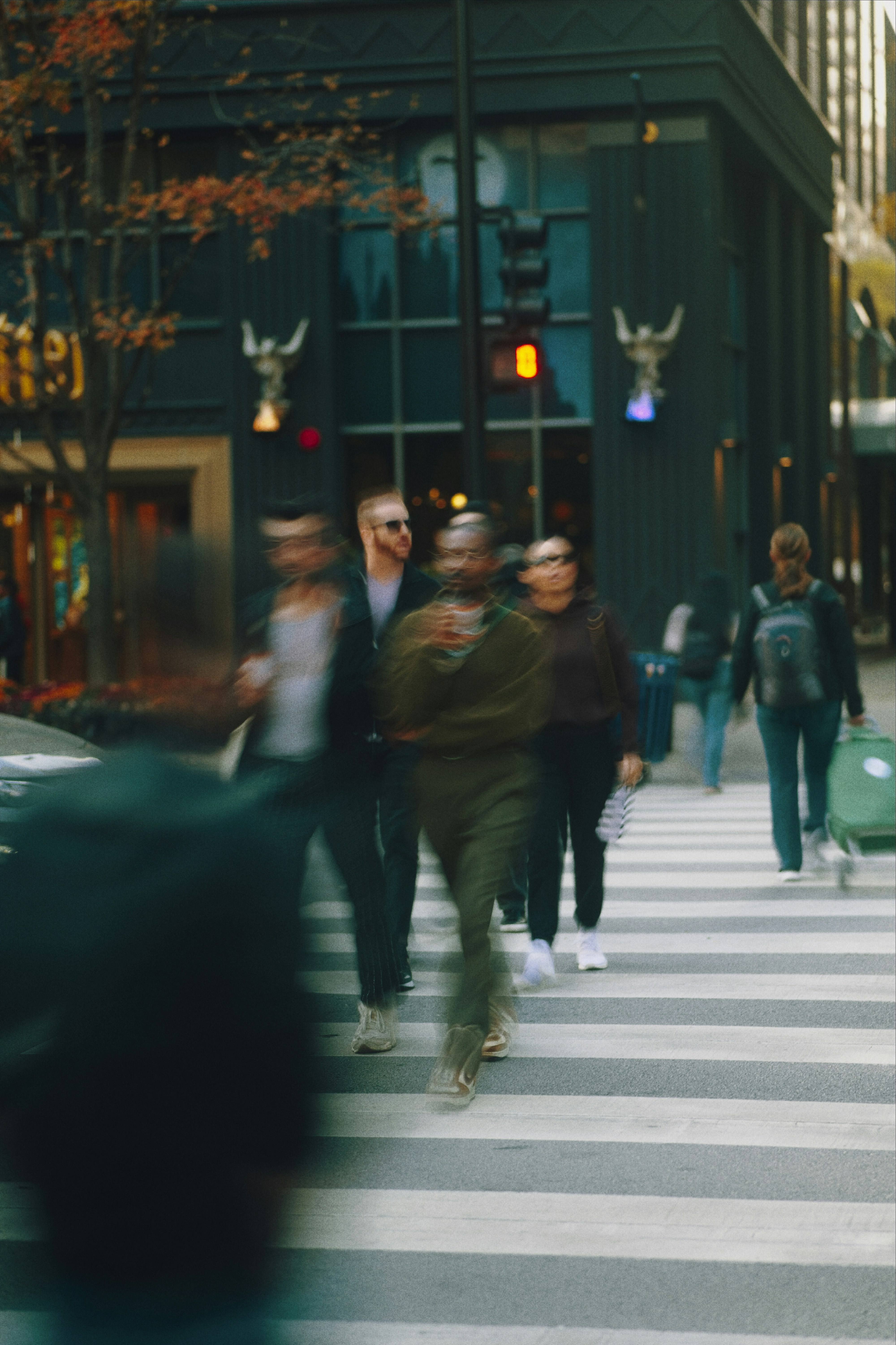 People crossing a busy city street at a crosswalk.