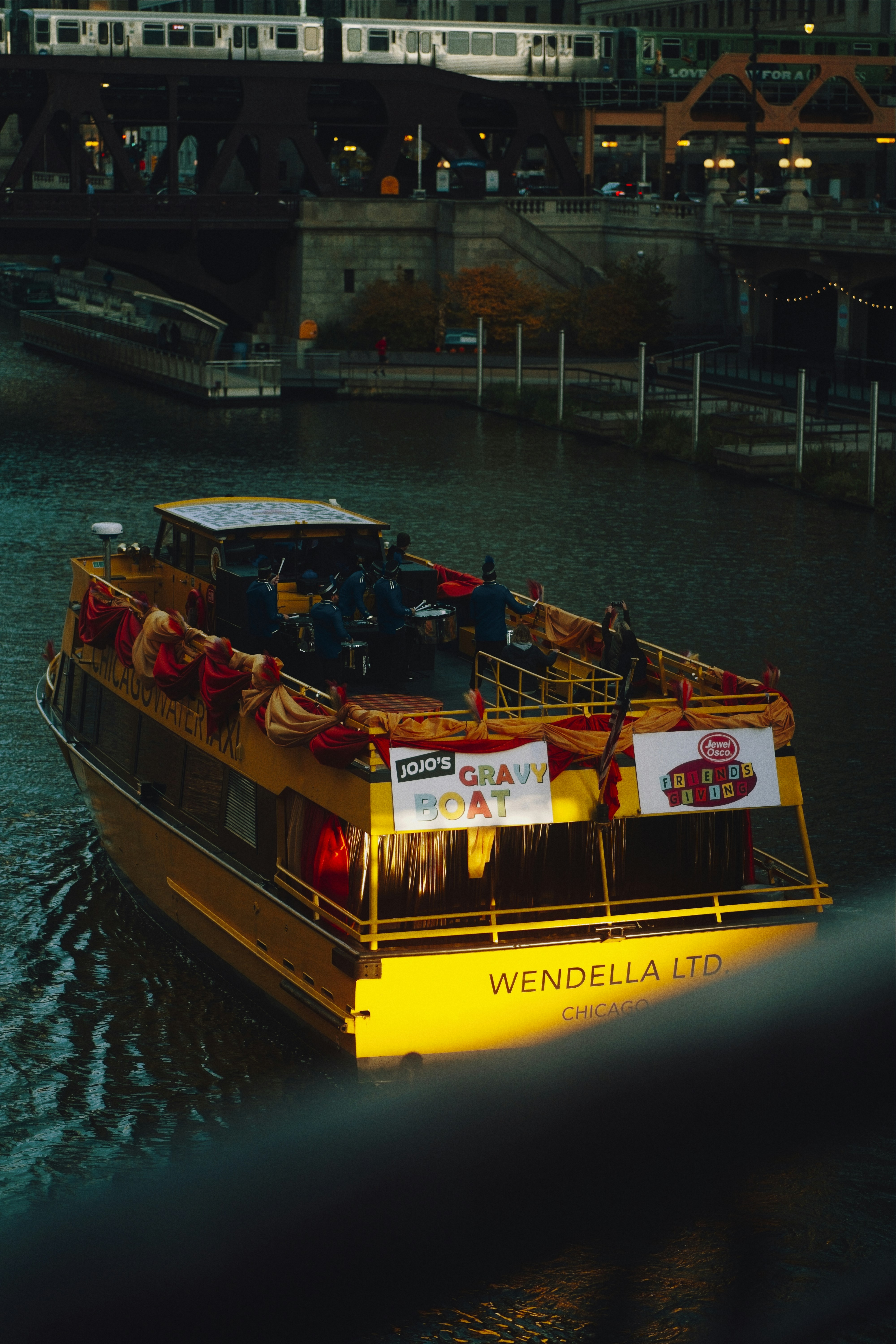 A yellow boat named wendella ltd sails on a river.