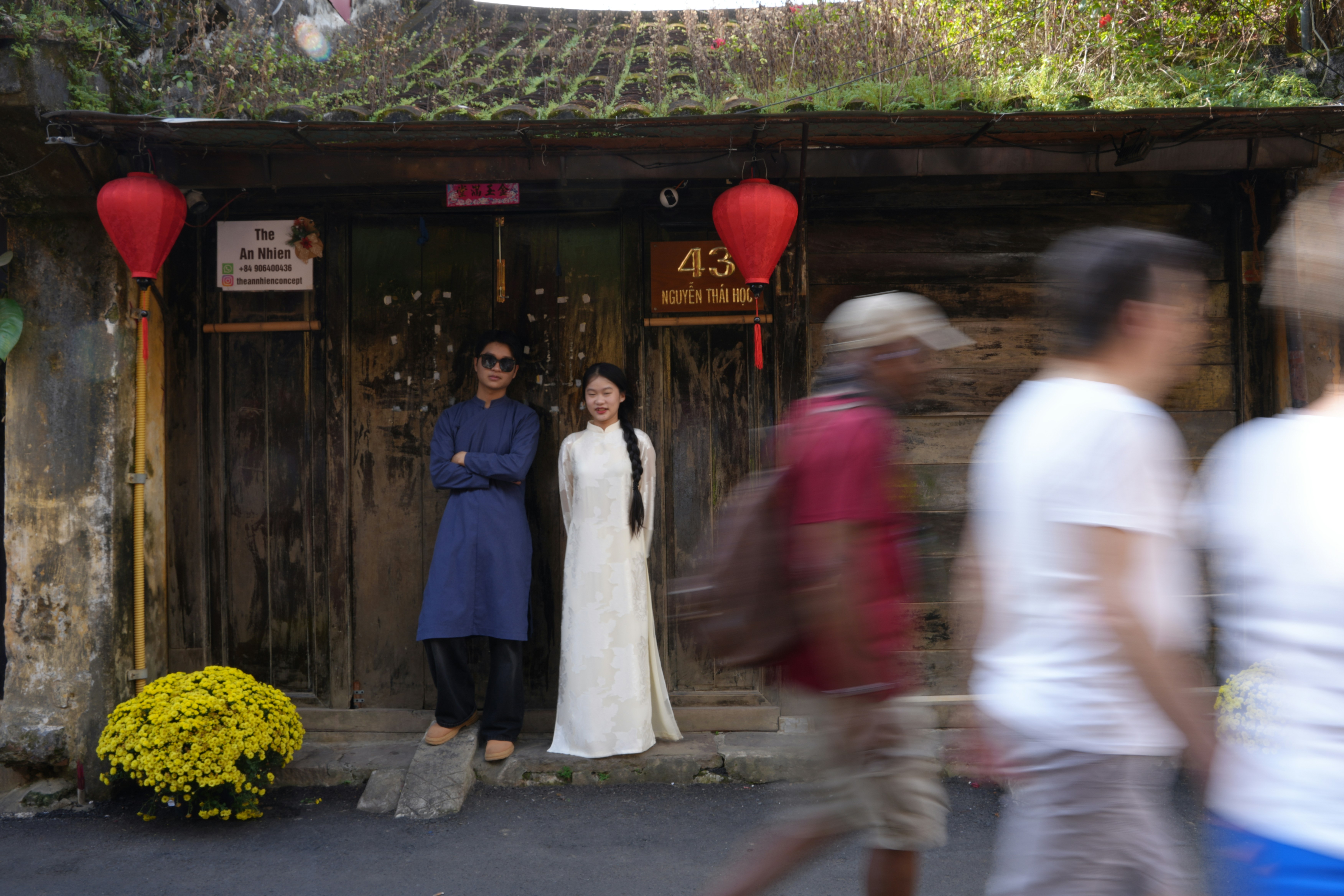 Couple in traditional vietnamese ao dai standing outside building