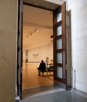 People sit in a modern art gallery through open doors