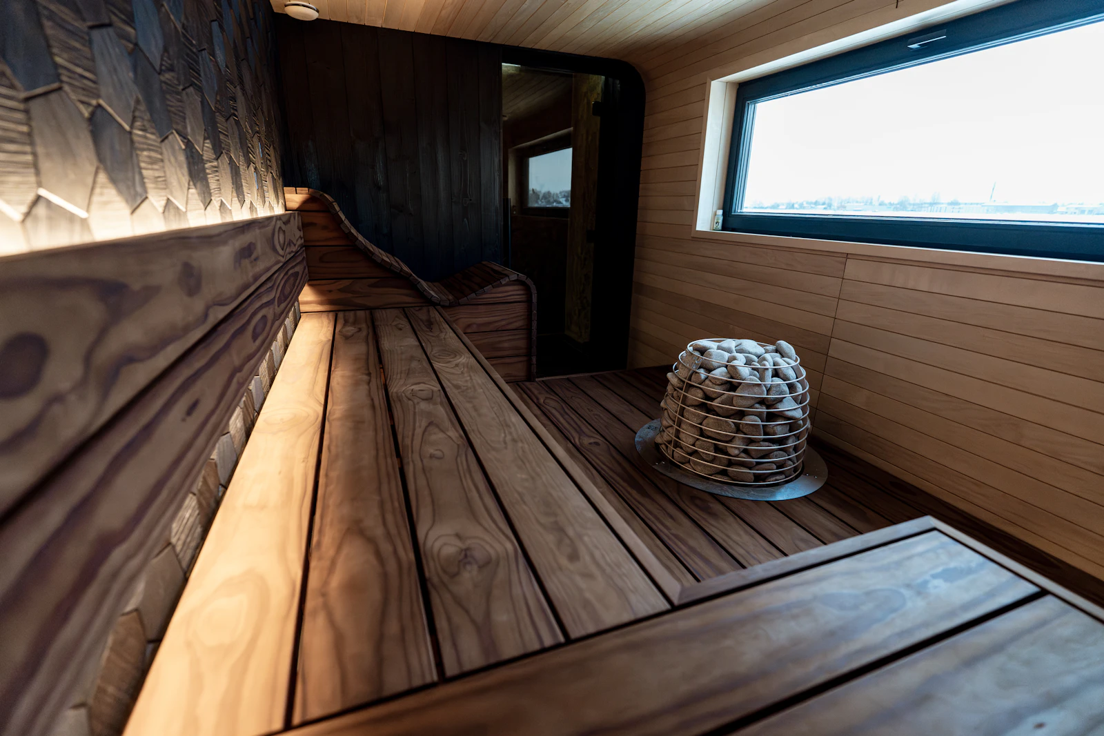Warm wooden sauna interior with a window and heater