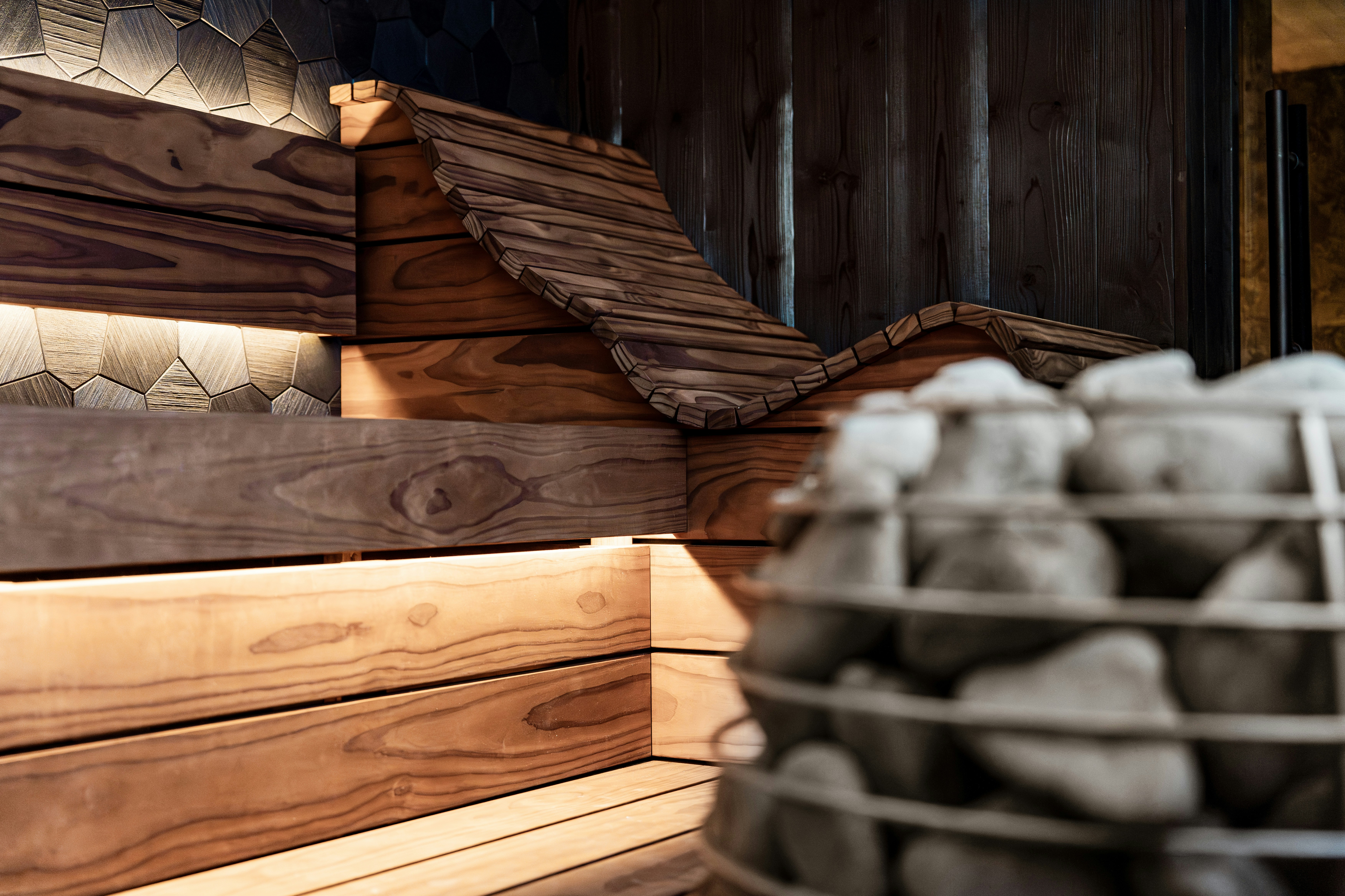 Wooden sauna interior with heater and ambient lighting