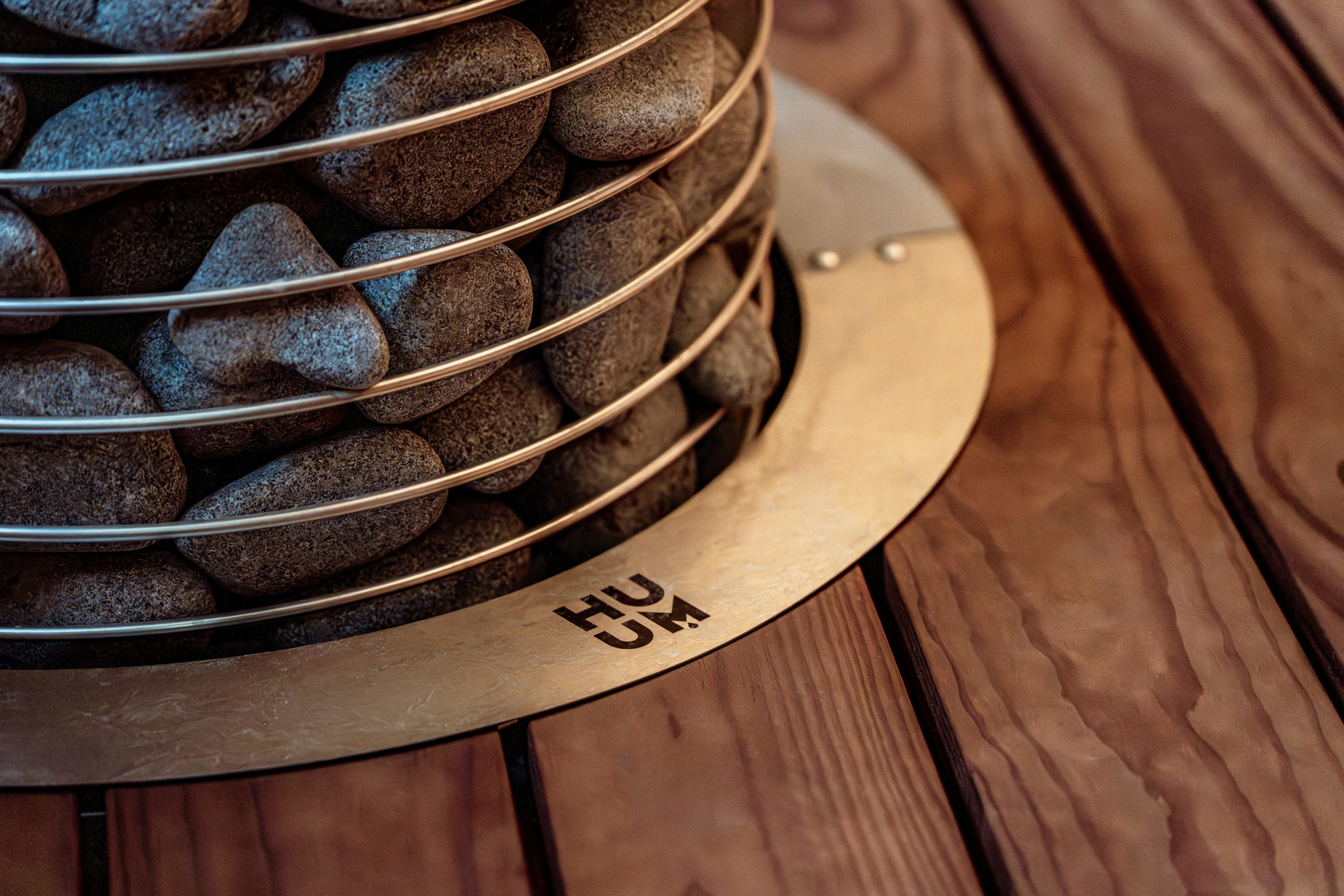 Close-up of a sauna heater with stones on wooden background