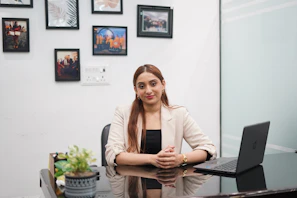 A woman sitting at a desk with a laptop.