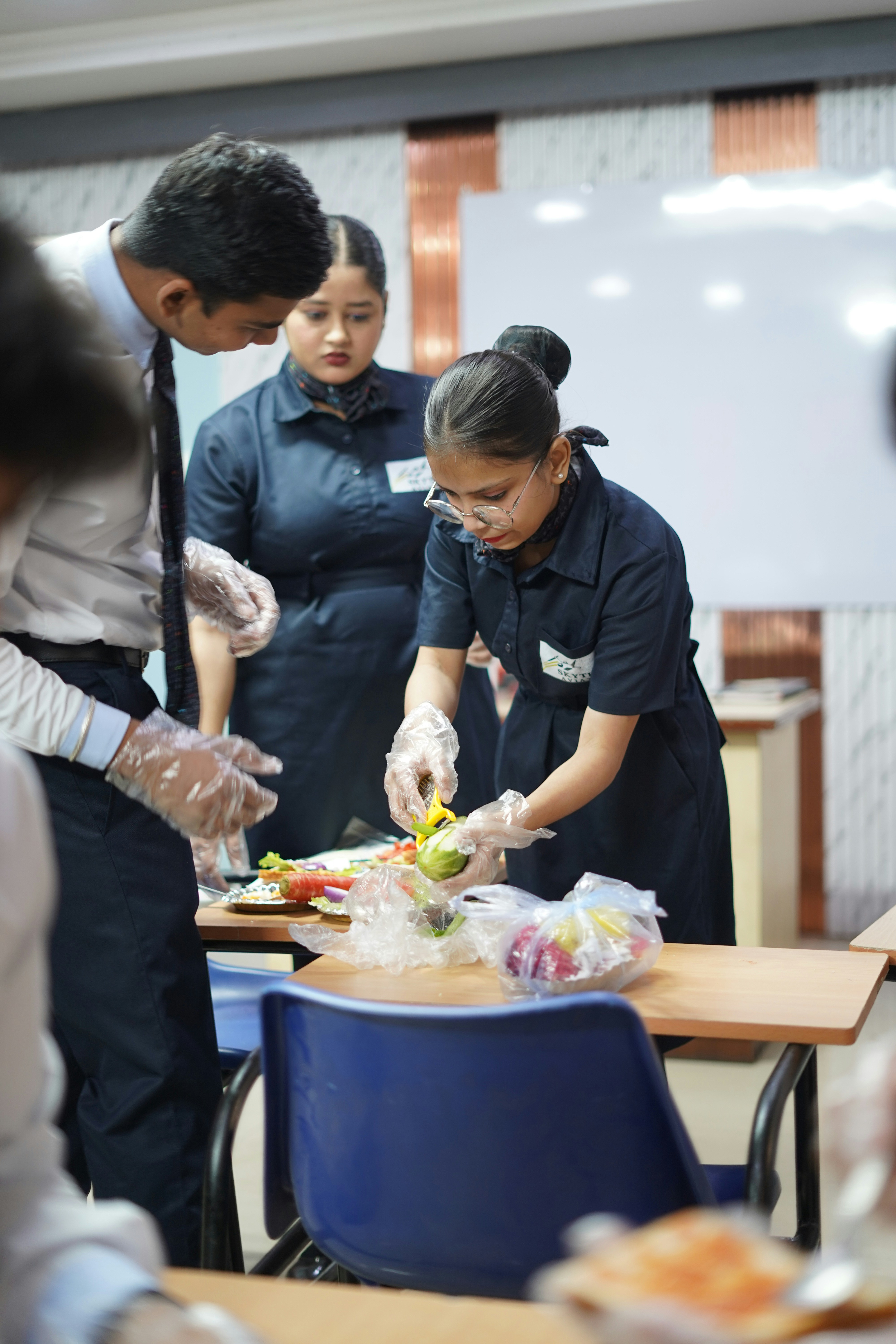 Alunos aprendendo a preparar comida em sala de aula.