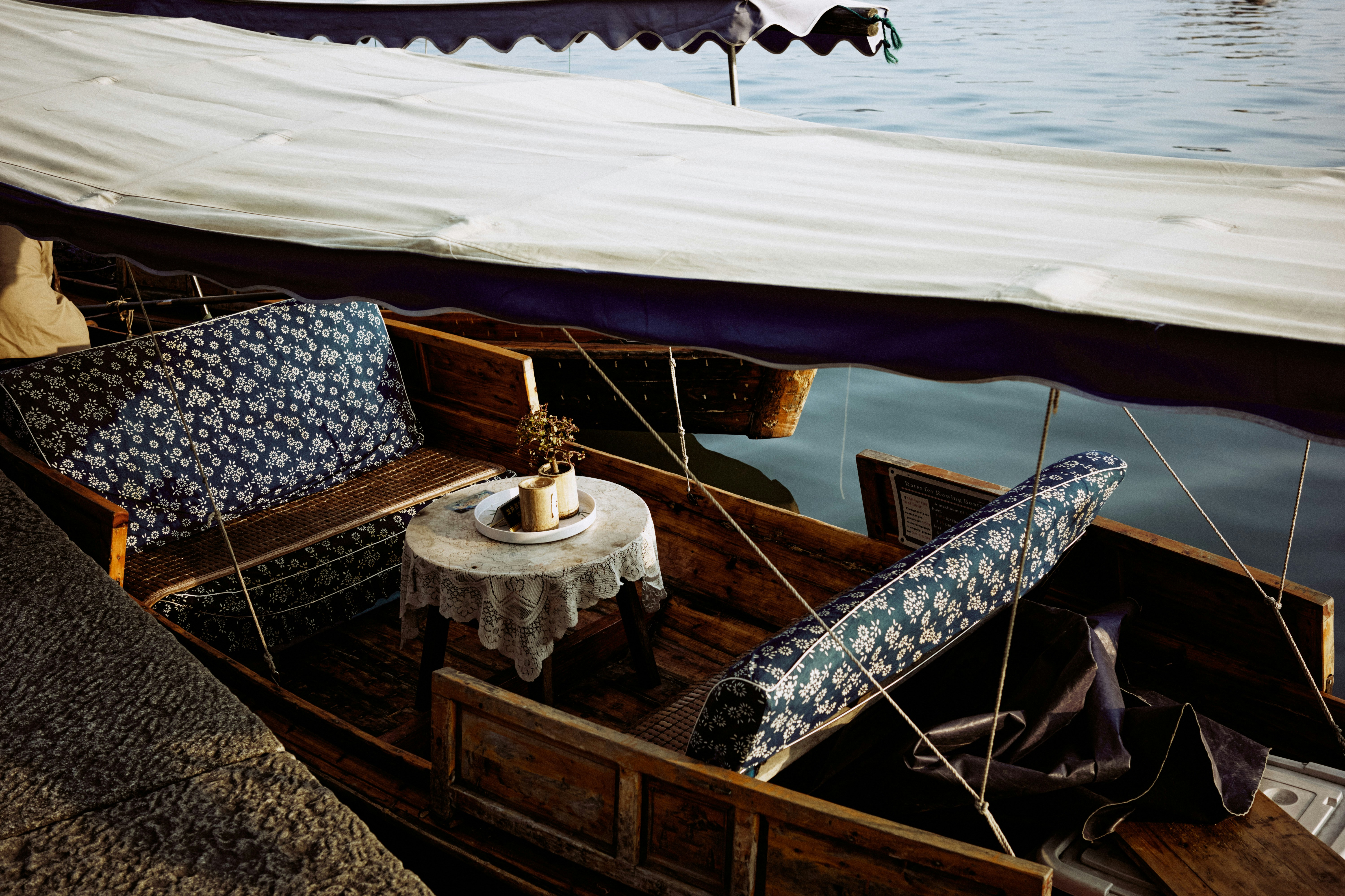 Wooden boat with patterned cushions and small table