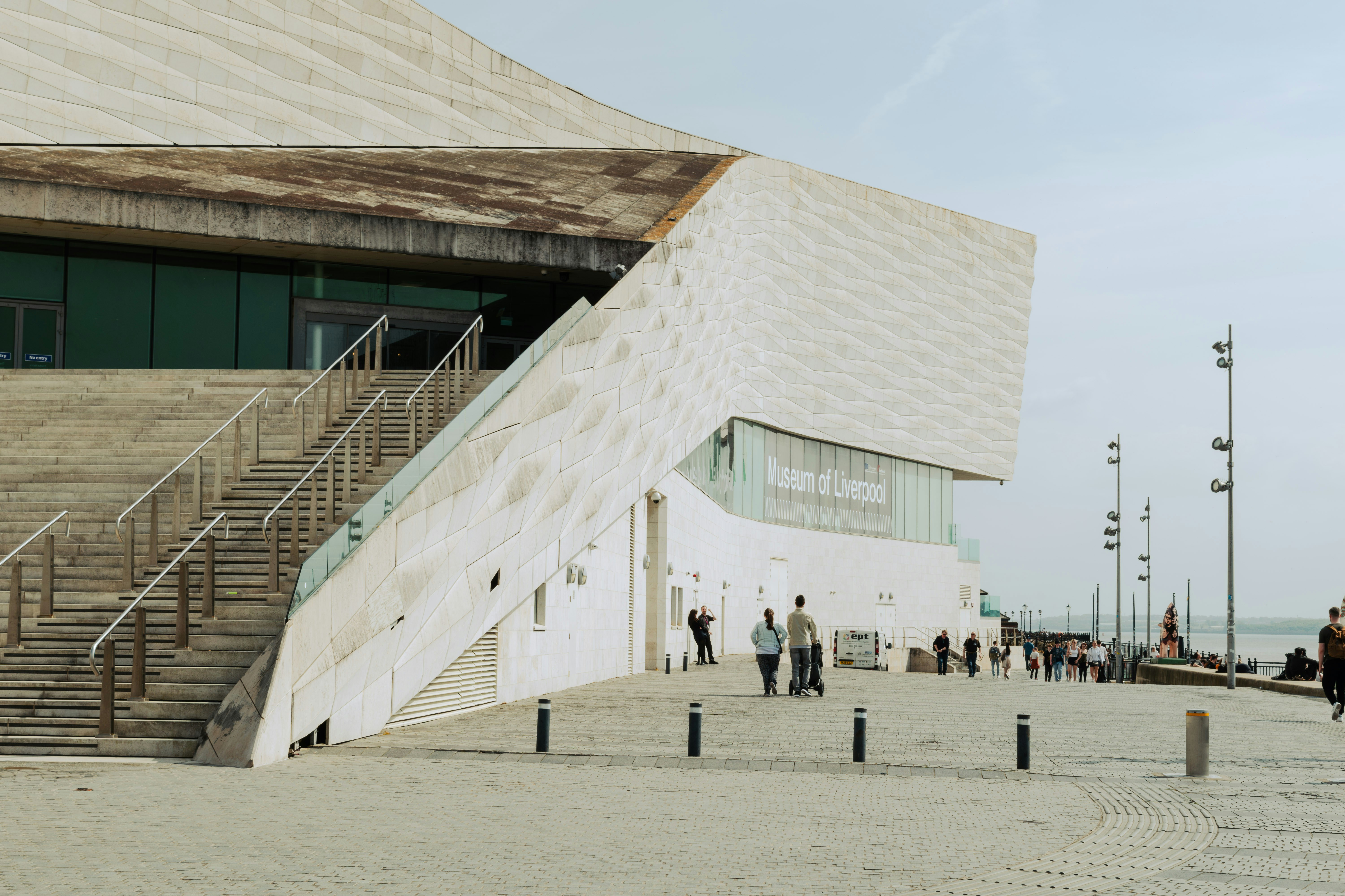 Bâtiment moderne avec escaliers et personnes qui sortent