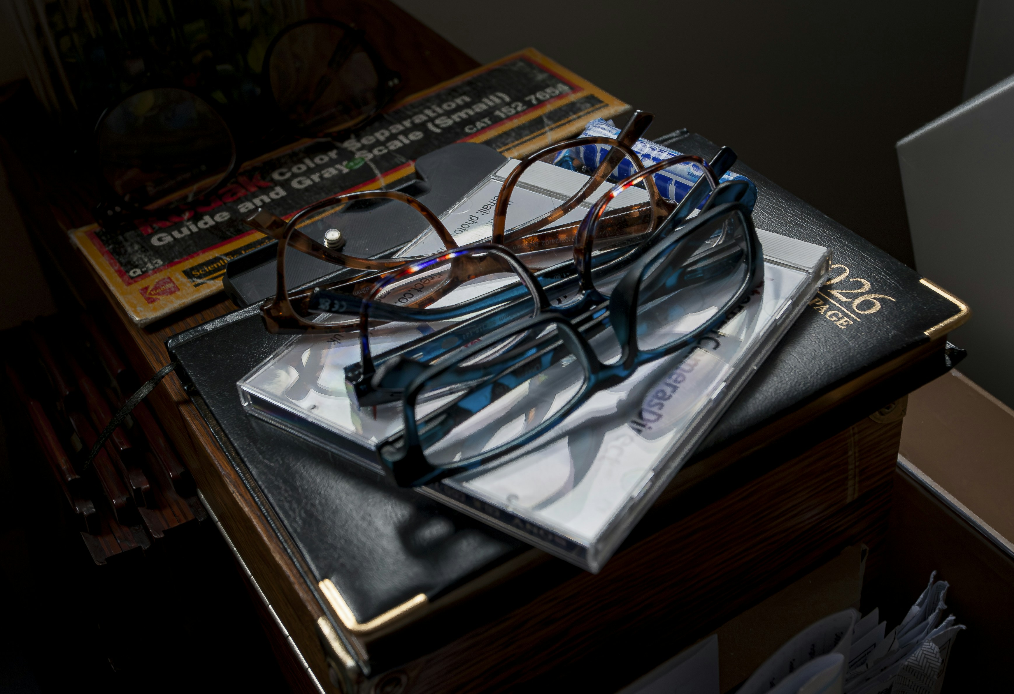 Two pairs of glasses resting on books
