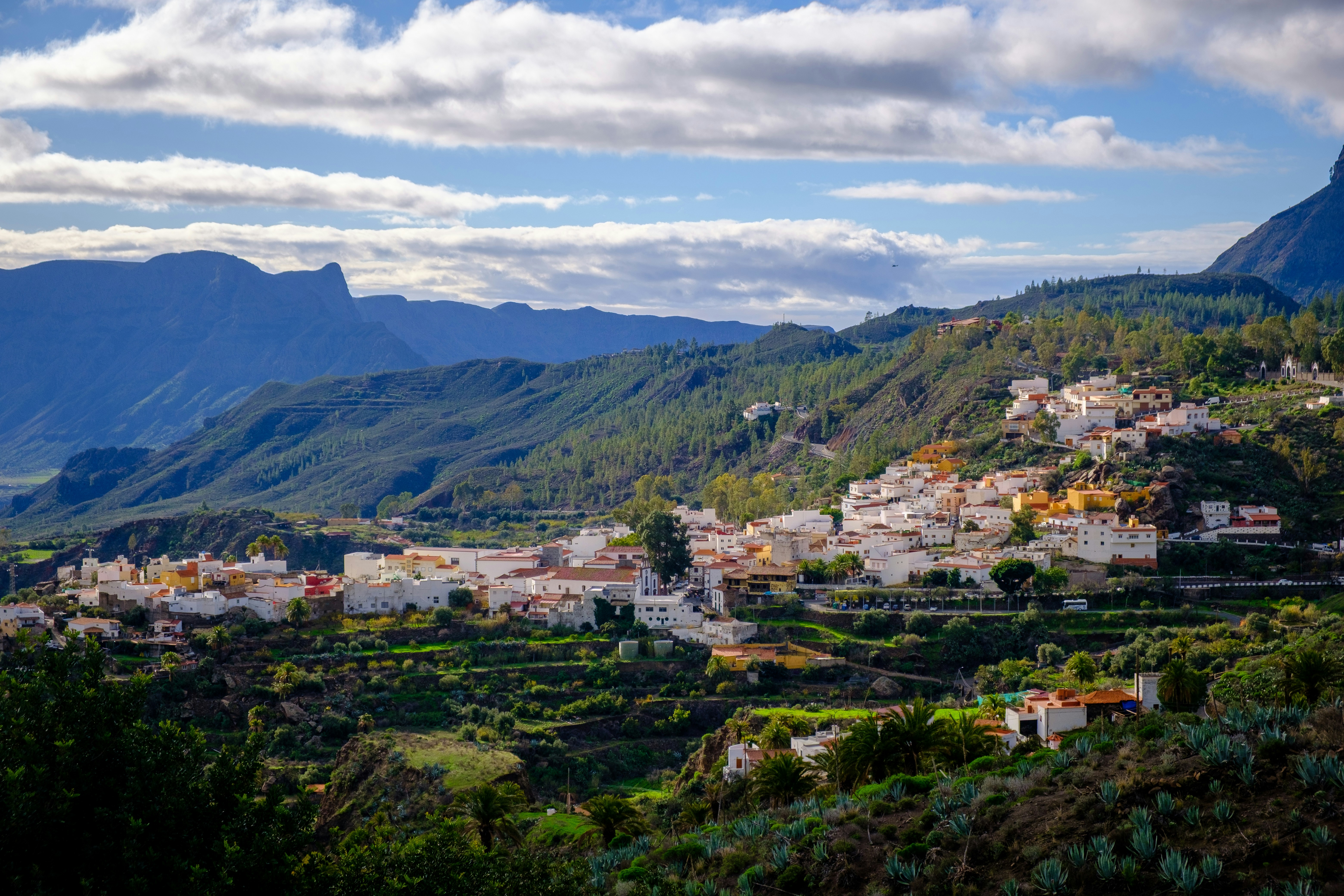 A small village nestled on a green, mountainous hillside.