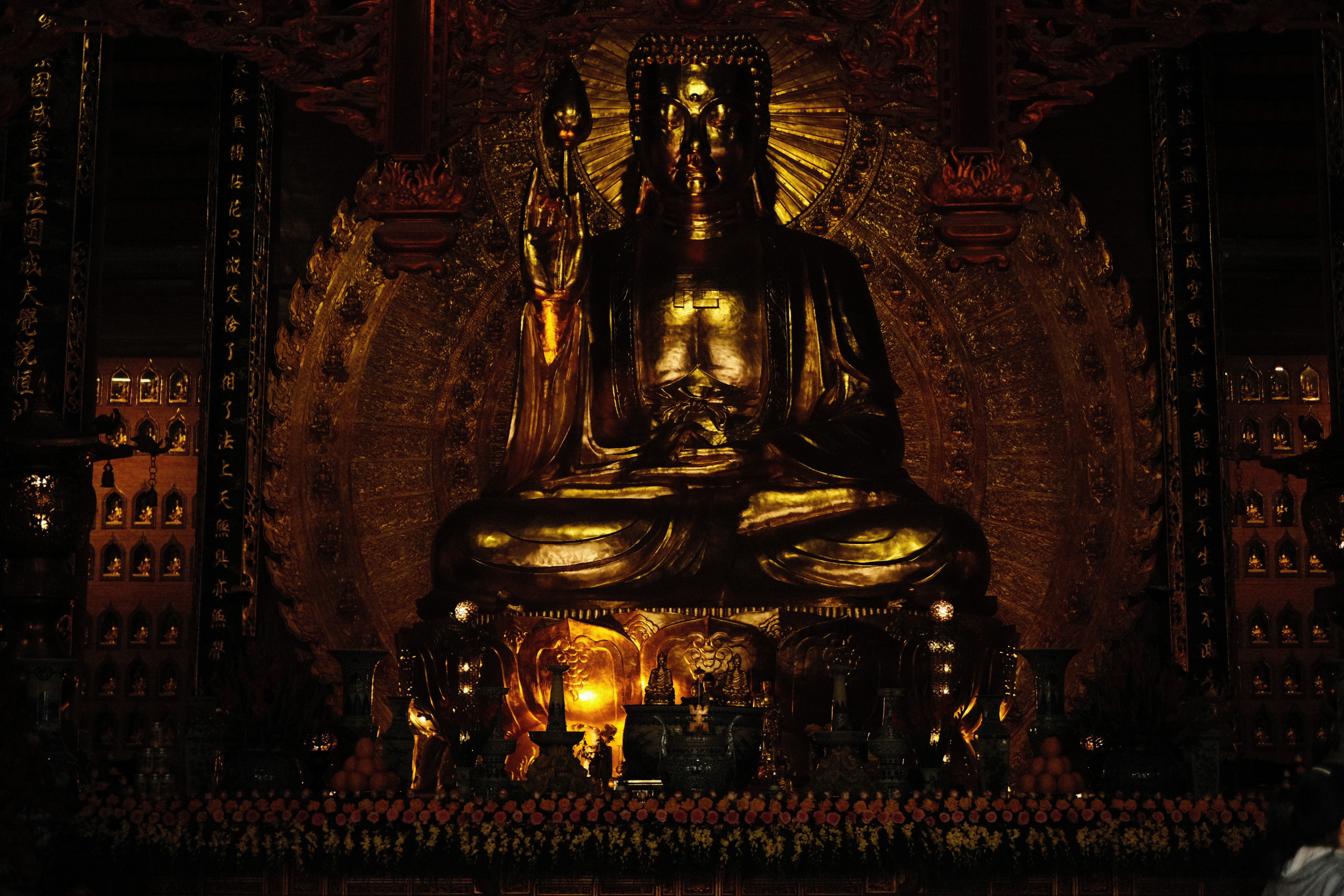 A large golden buddha statue in a dimly lit temple.