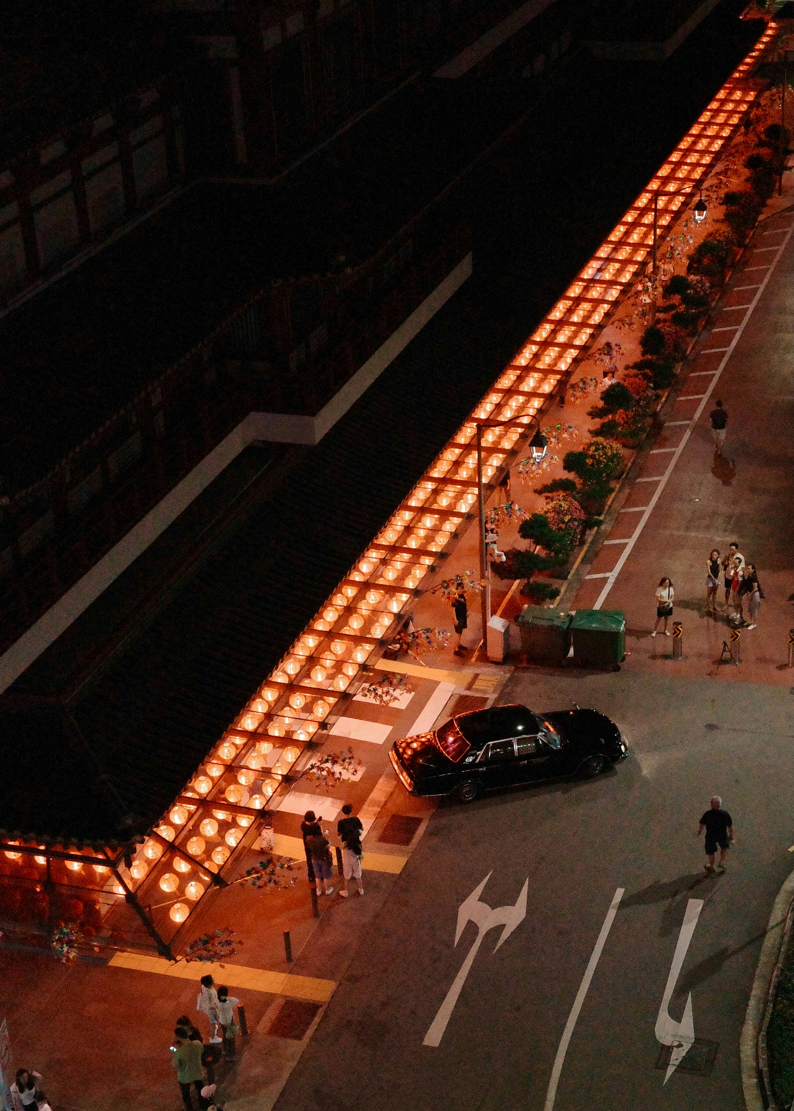 Un coche negro circula por una calle de noche.