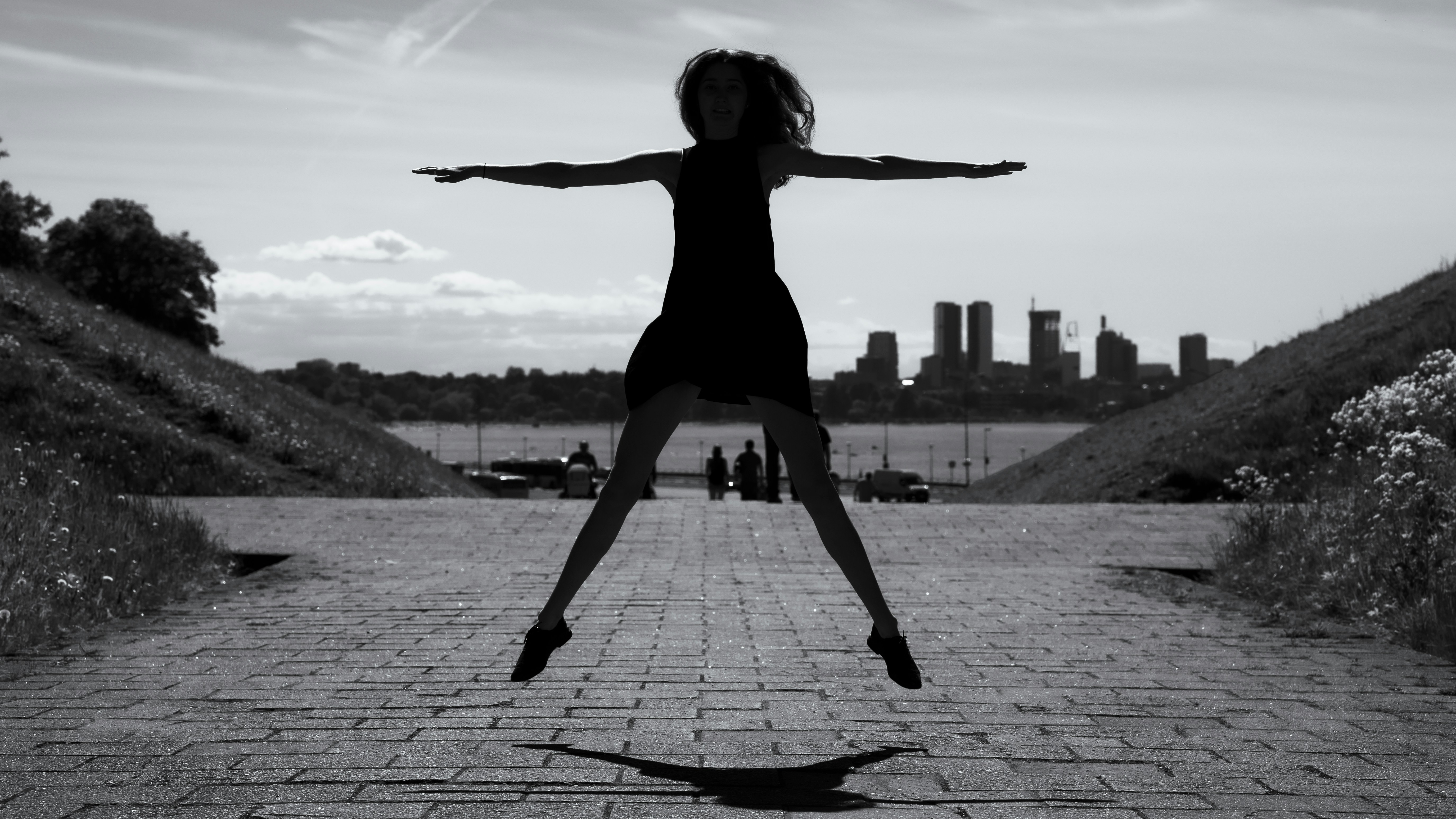 Silhouette of a woman jumping with city skyline background