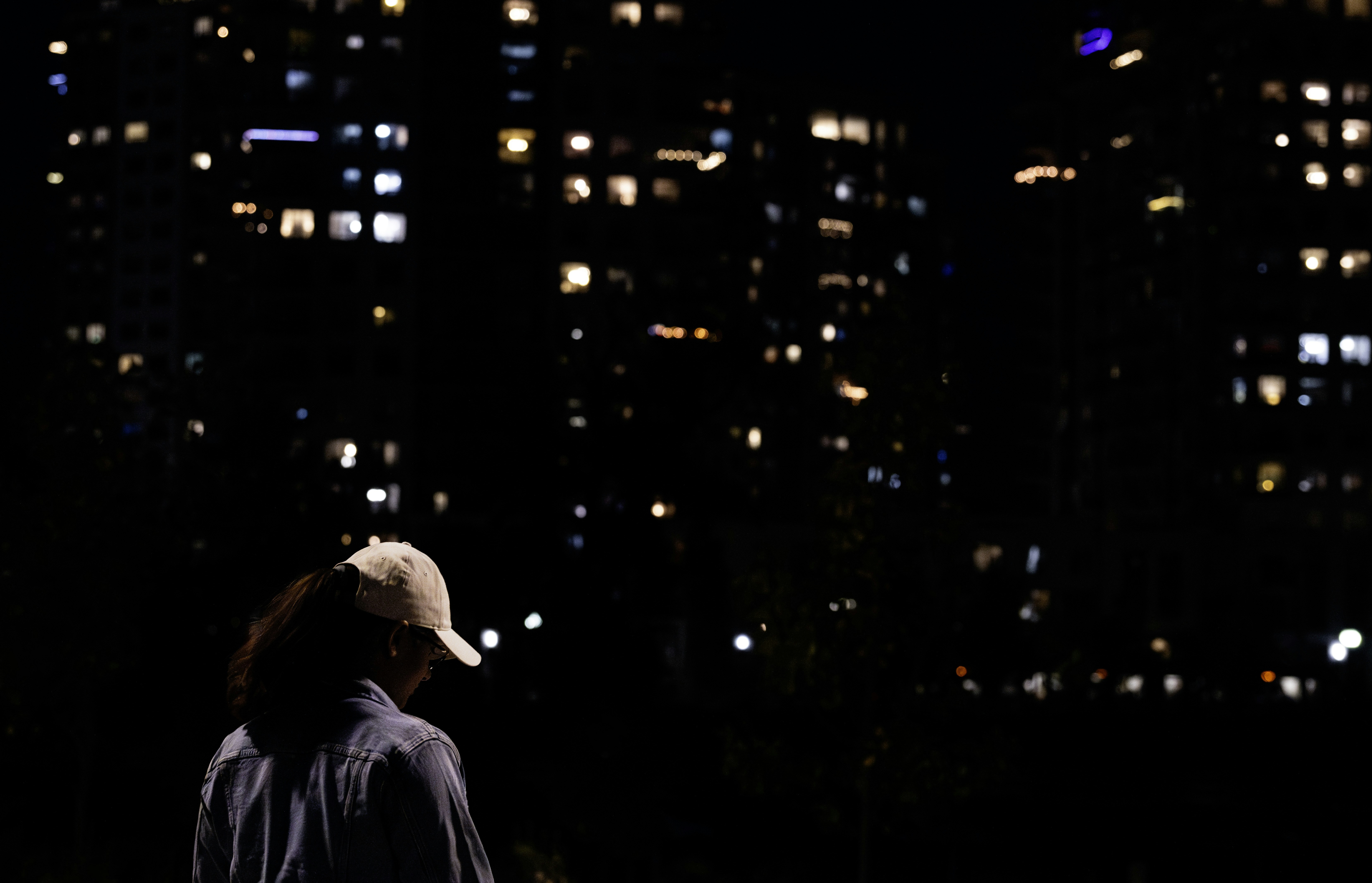 Person in foreground with city lights at night