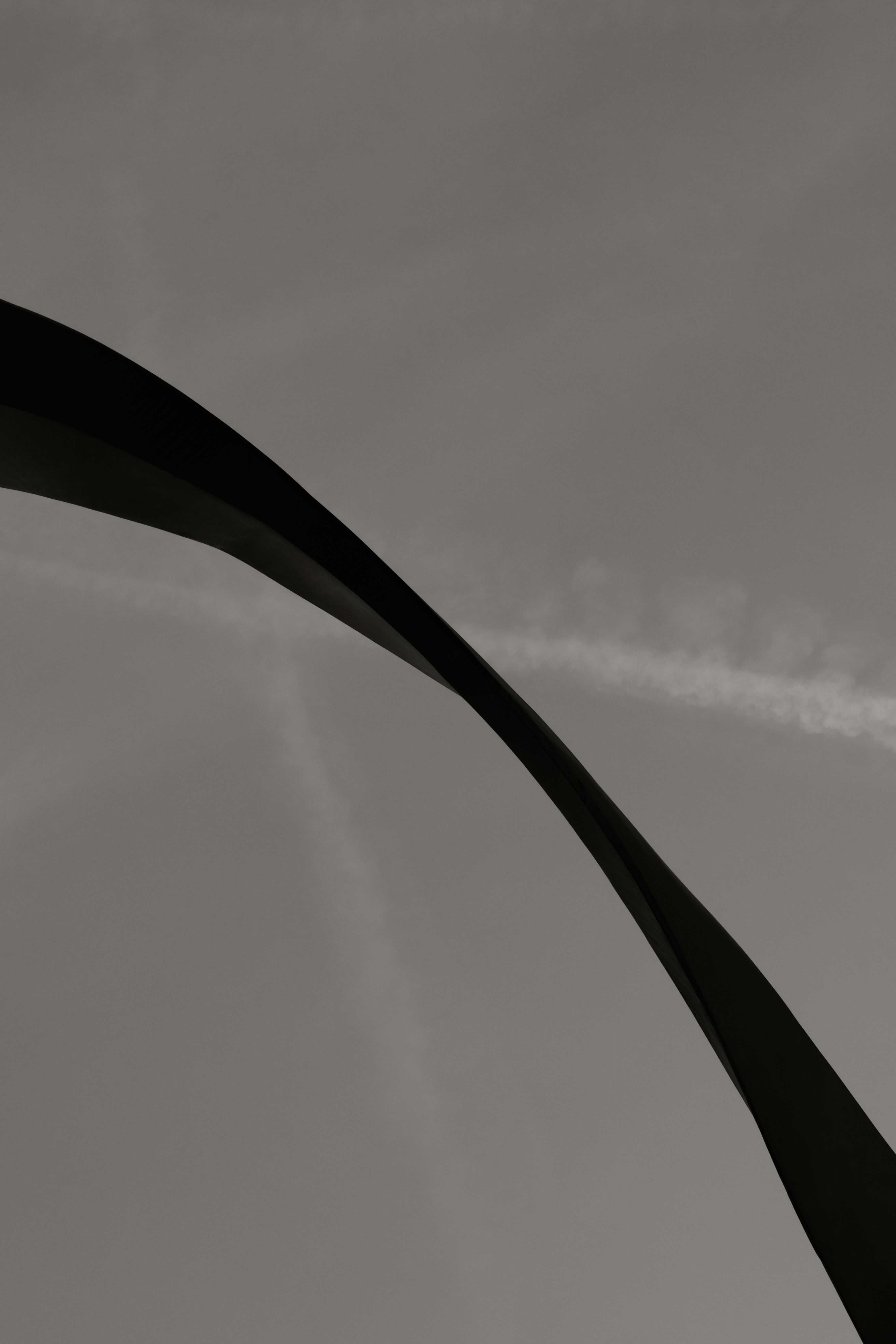 A dark arch against a cloudy sky