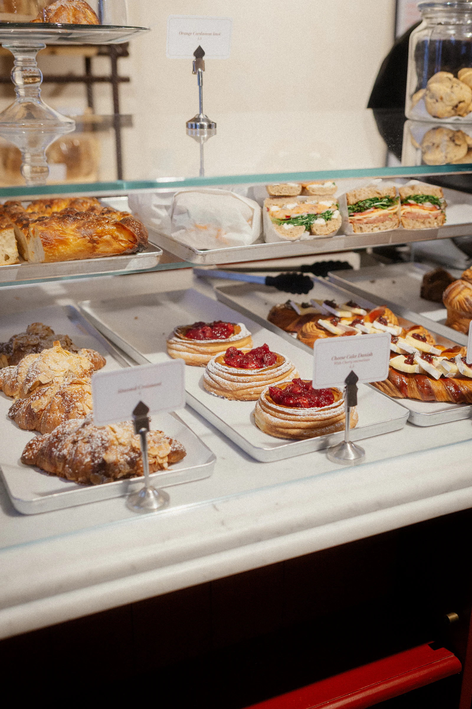 Patisserie counter filled with fresh pastries and sandwiches