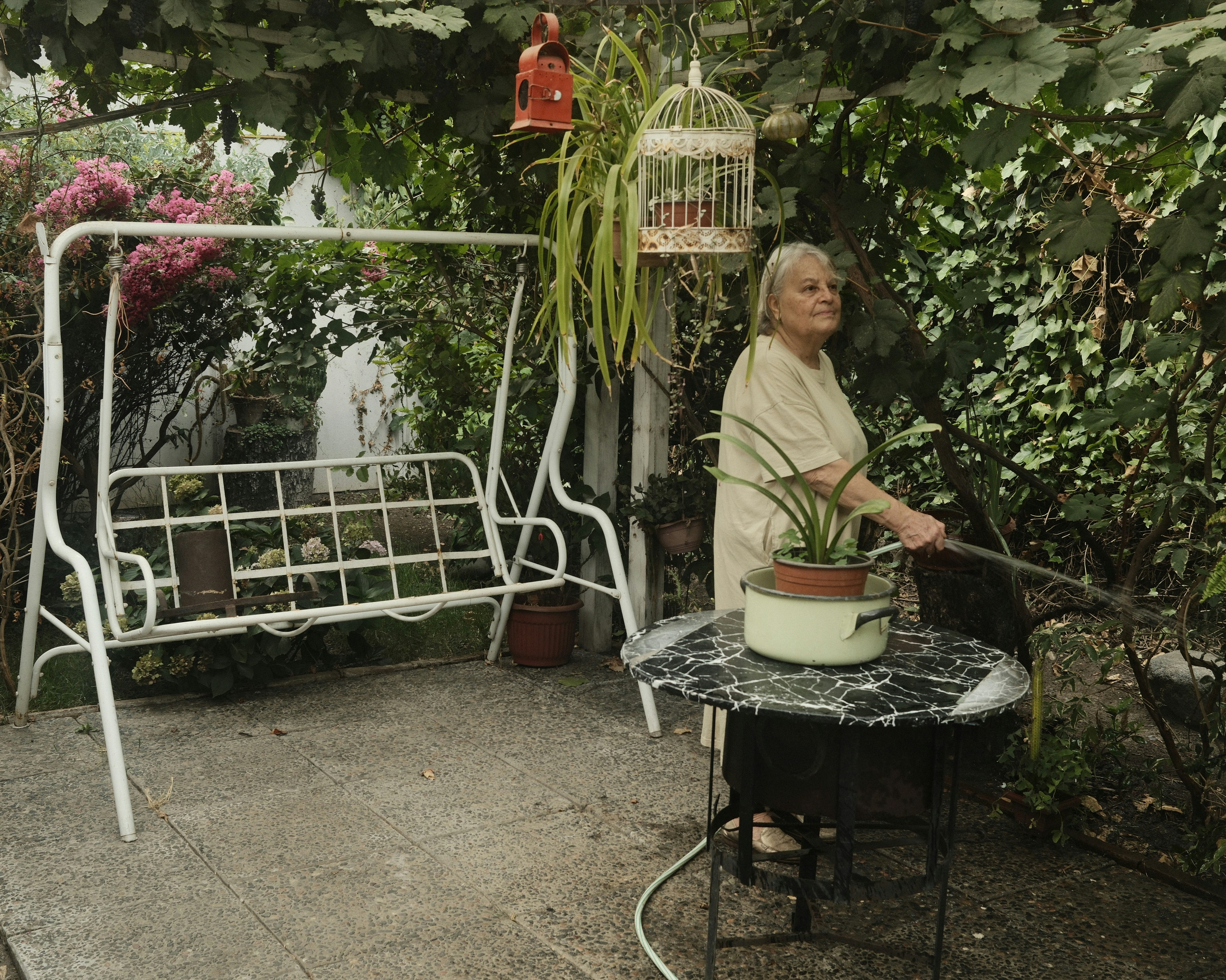 A vibrant photo showing a rural woman happily filling water from a newly installed tap in her home, with lush greenery in the background.