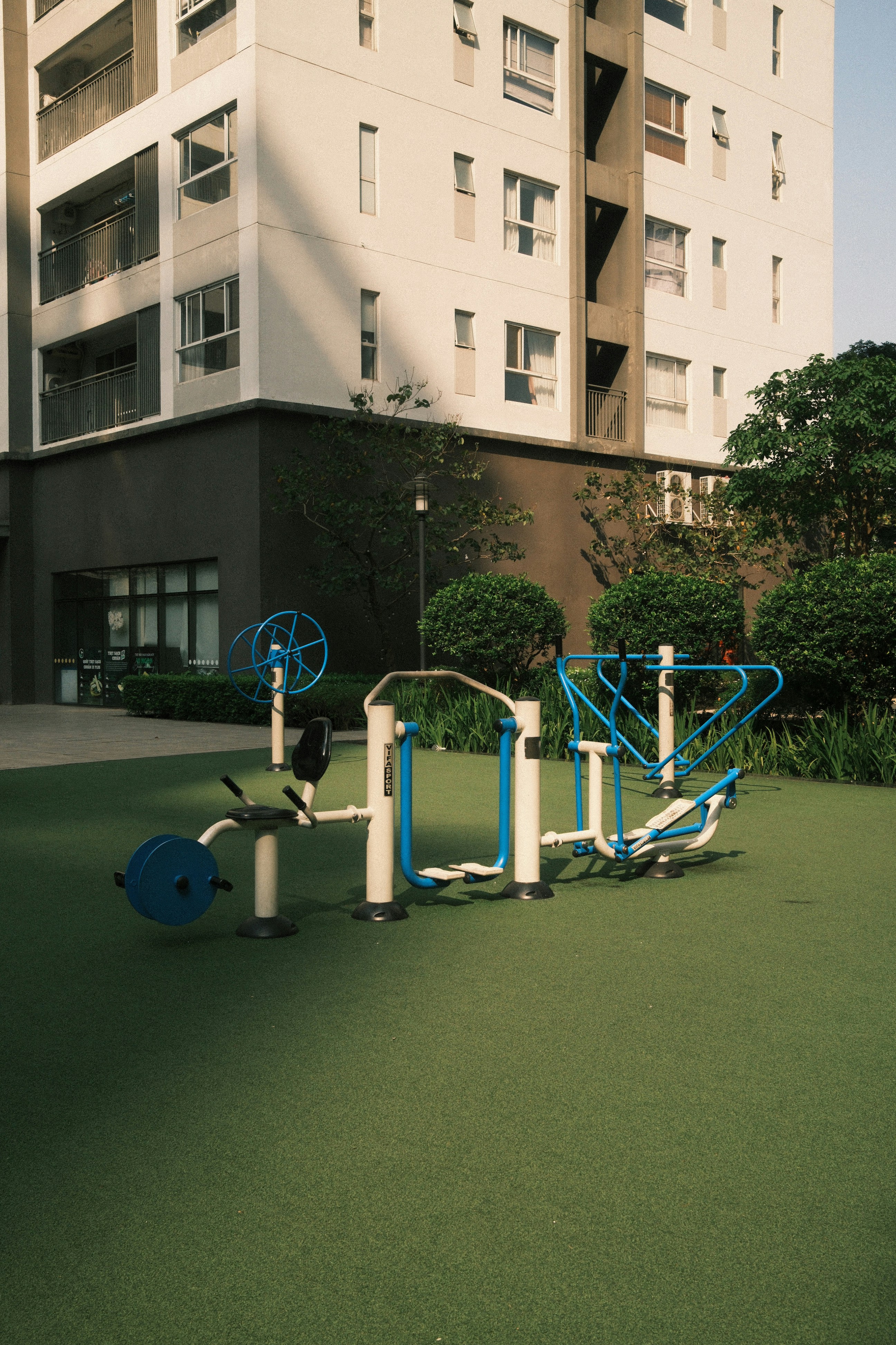 Outdoor gym equipment on green turf near building