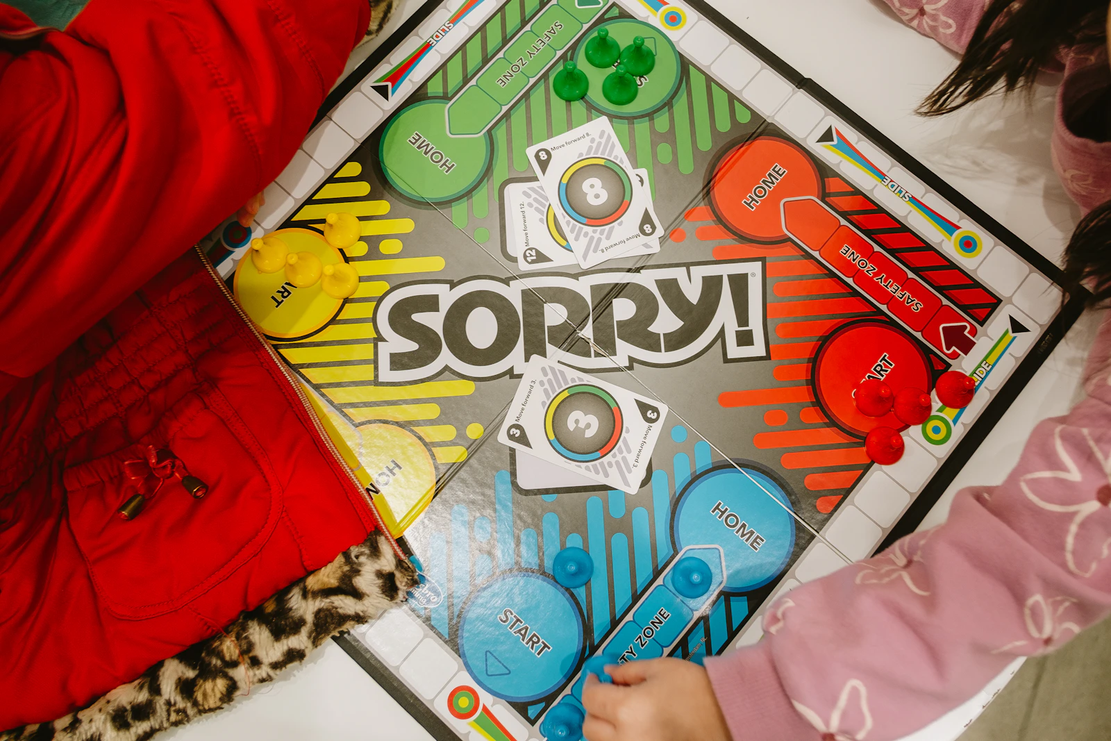 Children gathered around a colorful board game during playtime