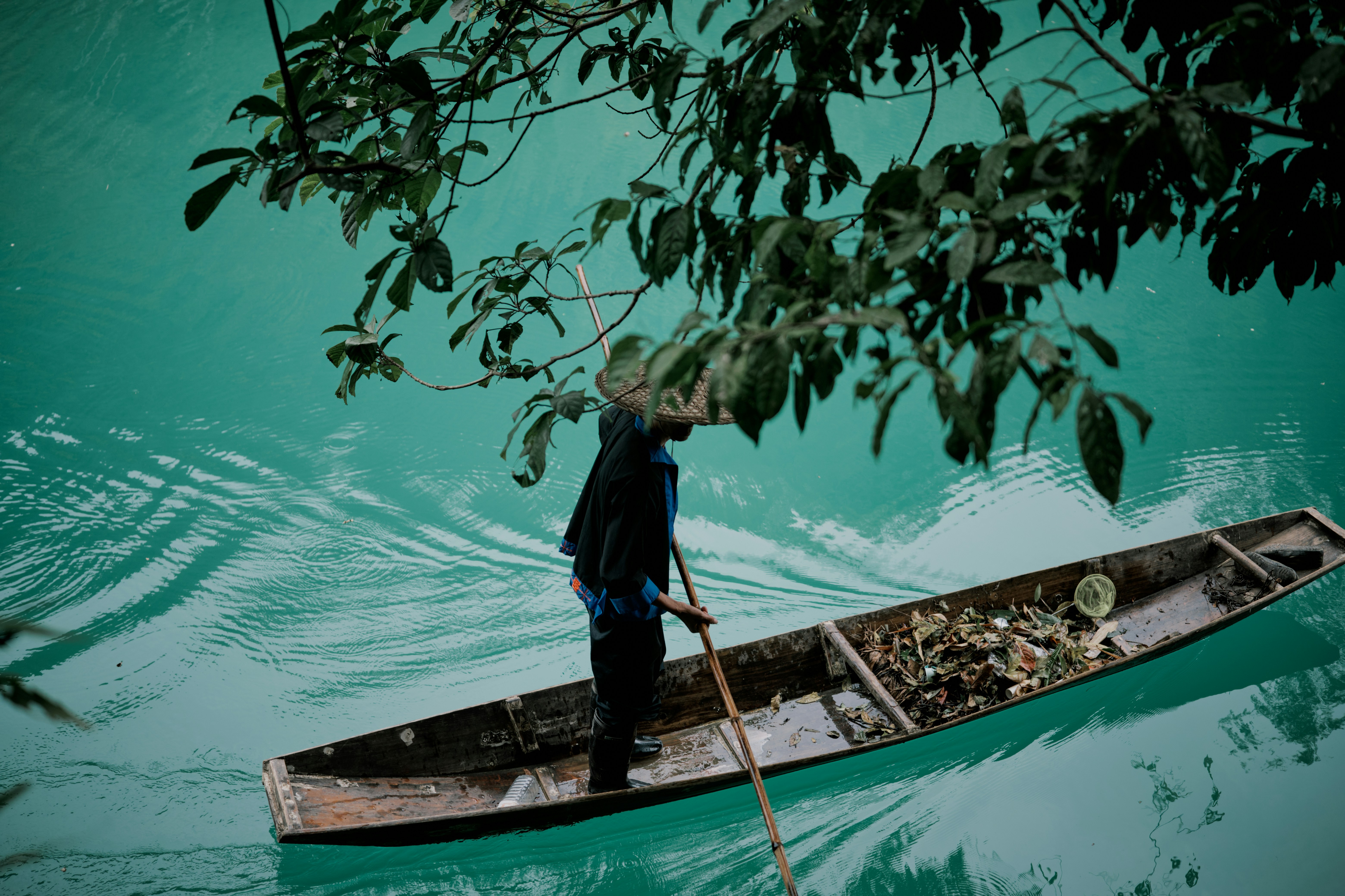 Person rows a boat on turquoise water