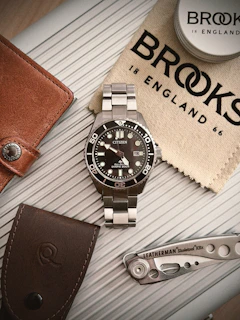 A stainless steel citizen watch with leather accessories.