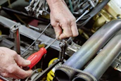Mechanic working on car engine with tools