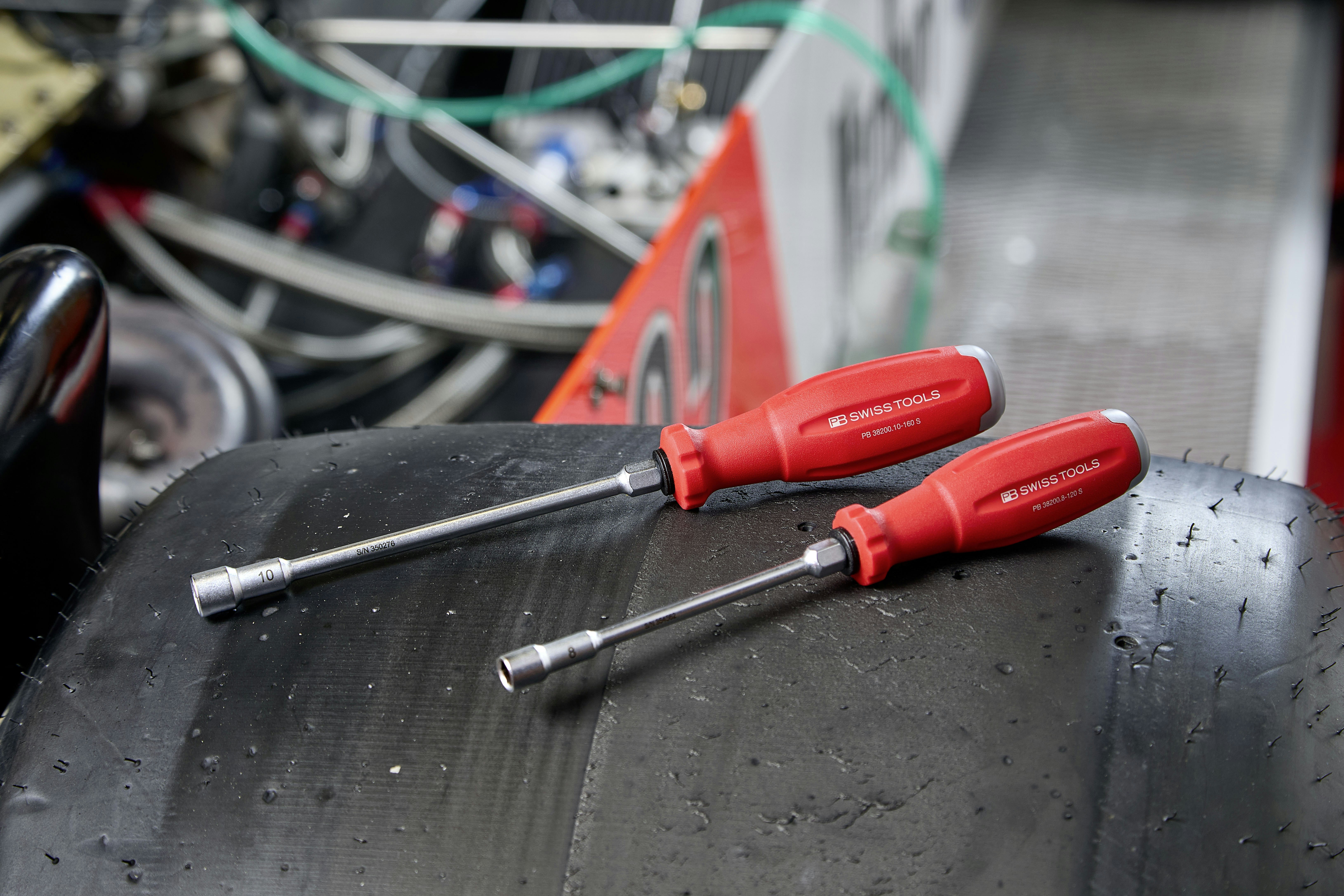 Two red handled socket drivers on a tire.