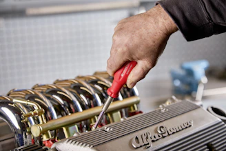 Mechanic using screwdriver on car engine