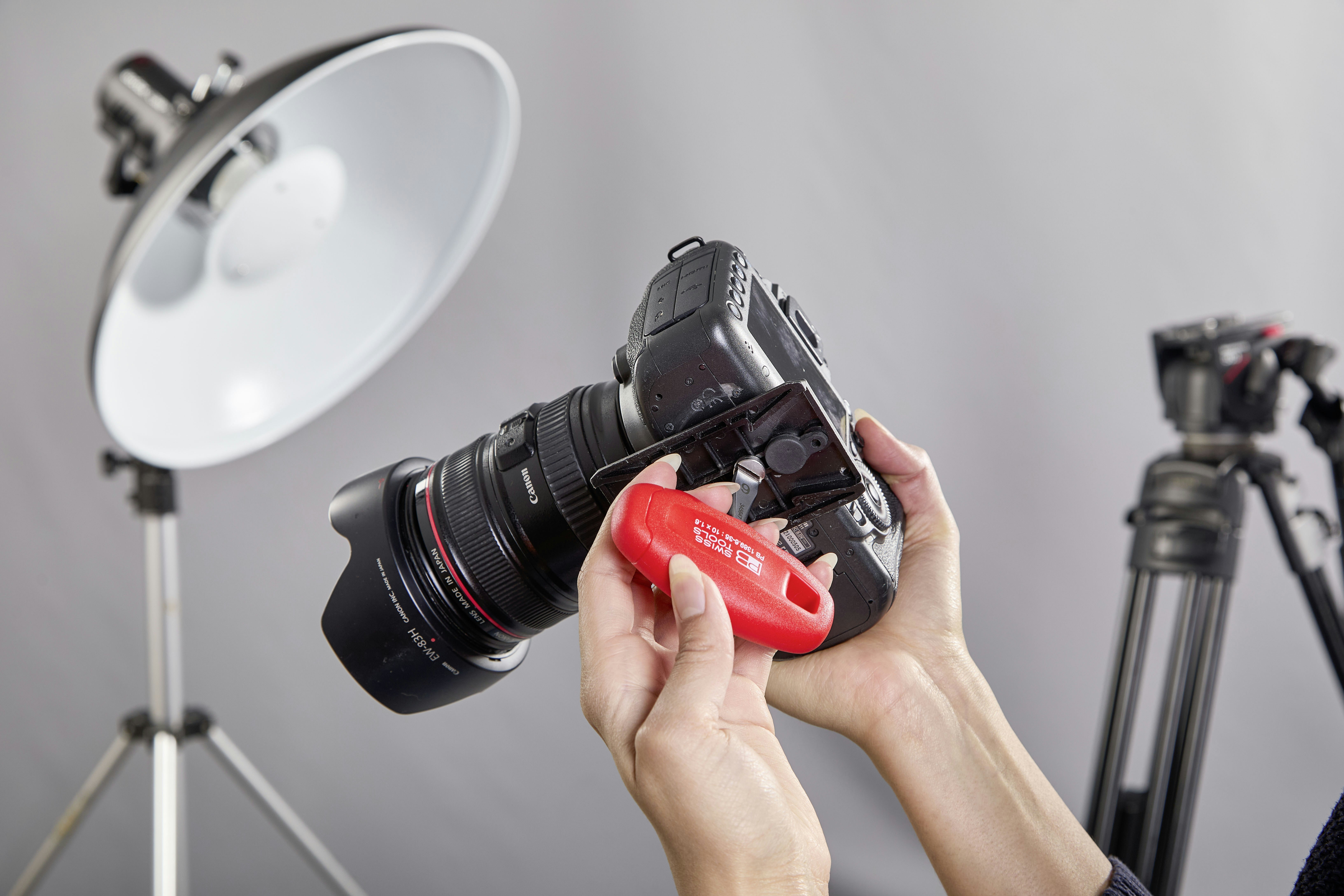 Hands holding a camera with a red remote trigger