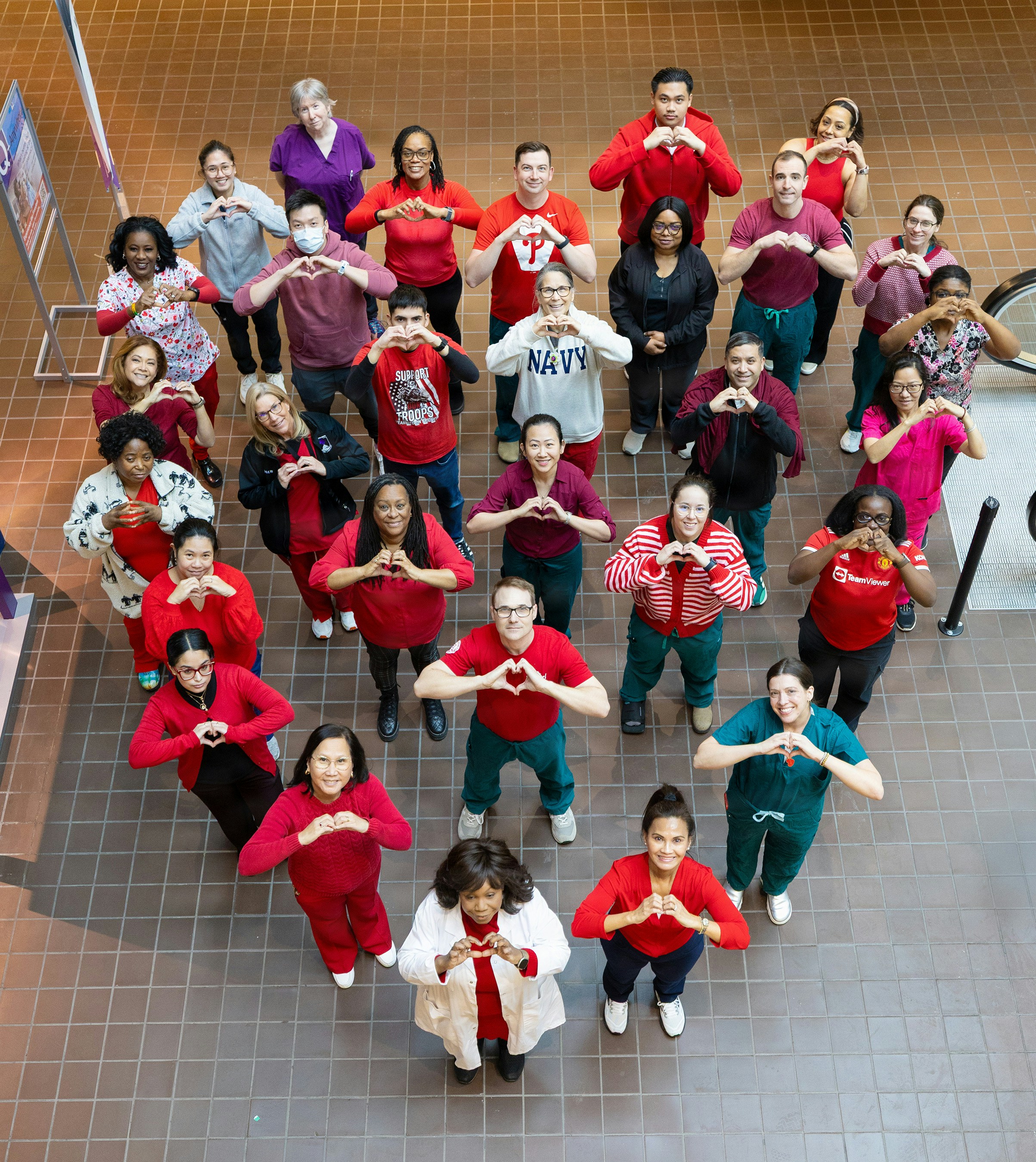 Group of people forming a heart shape with hands