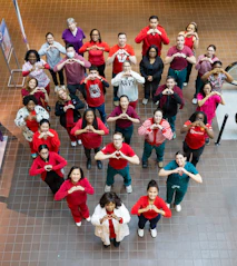 Group of people forming a heart shape with hands