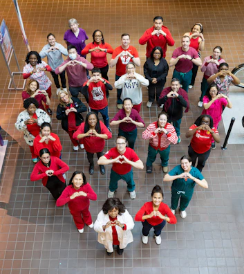 Group of people forming a heart shape with hands