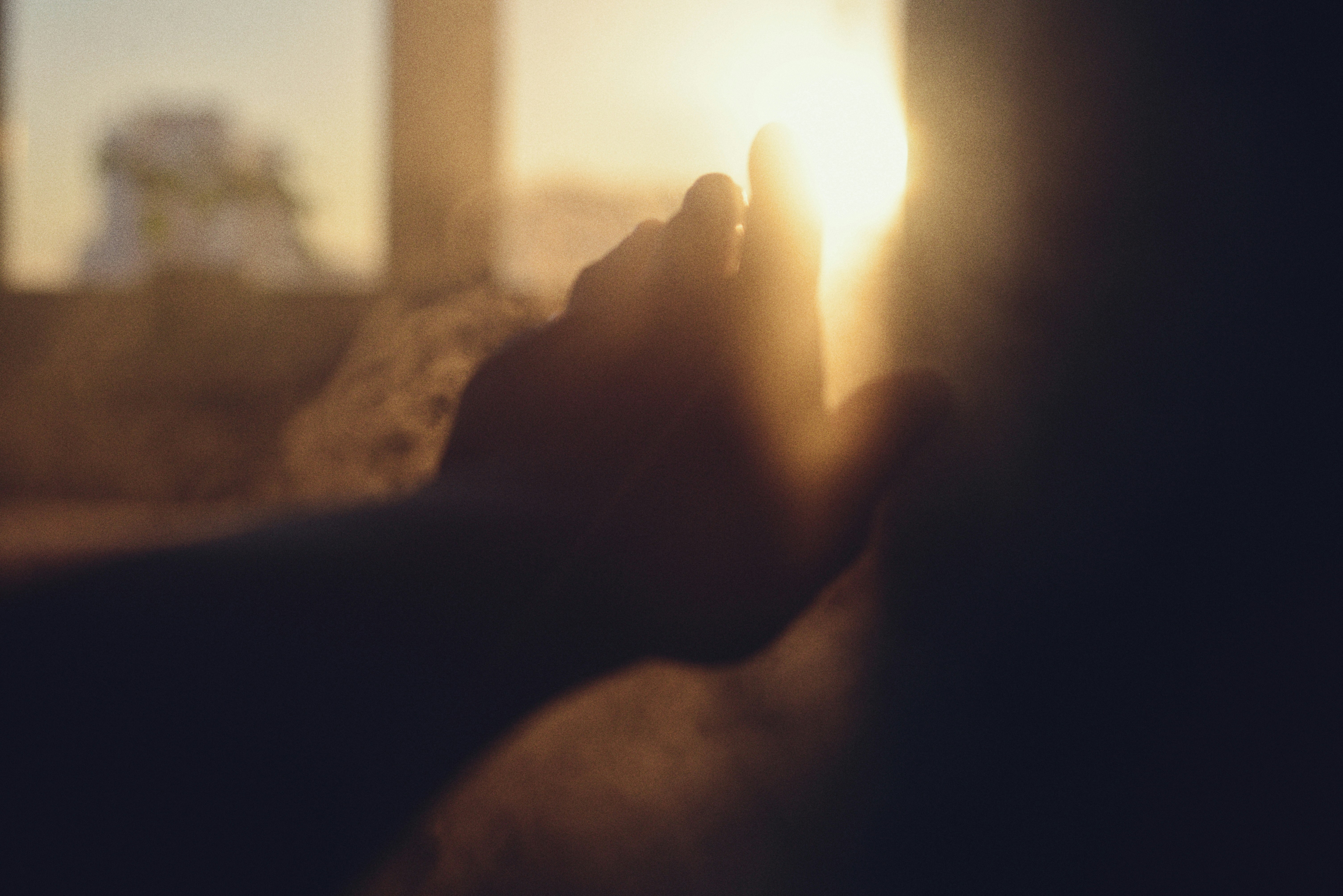 La lumière du soleil traverse les mains d’une personne.