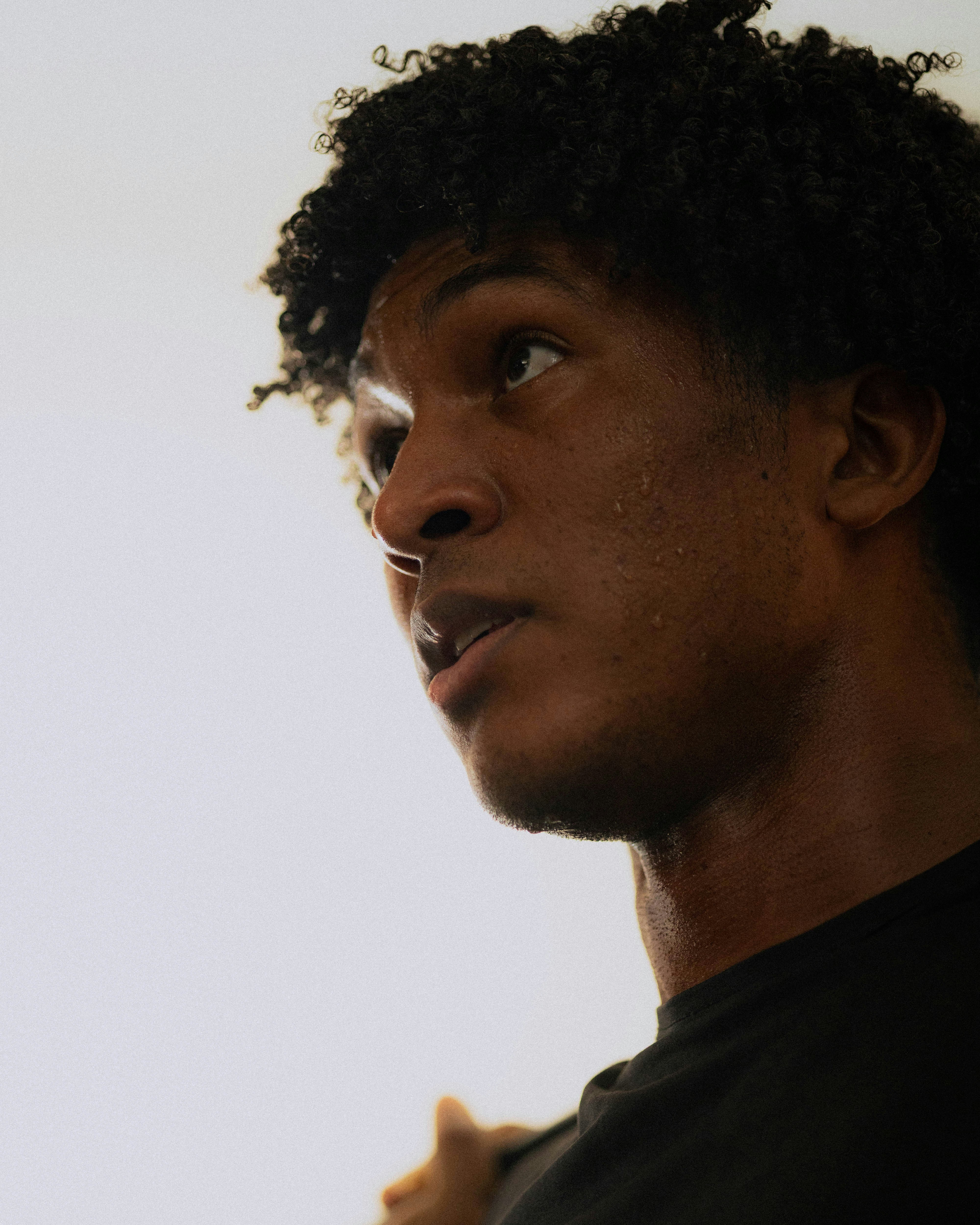 A man with curly hair sweating intensely.