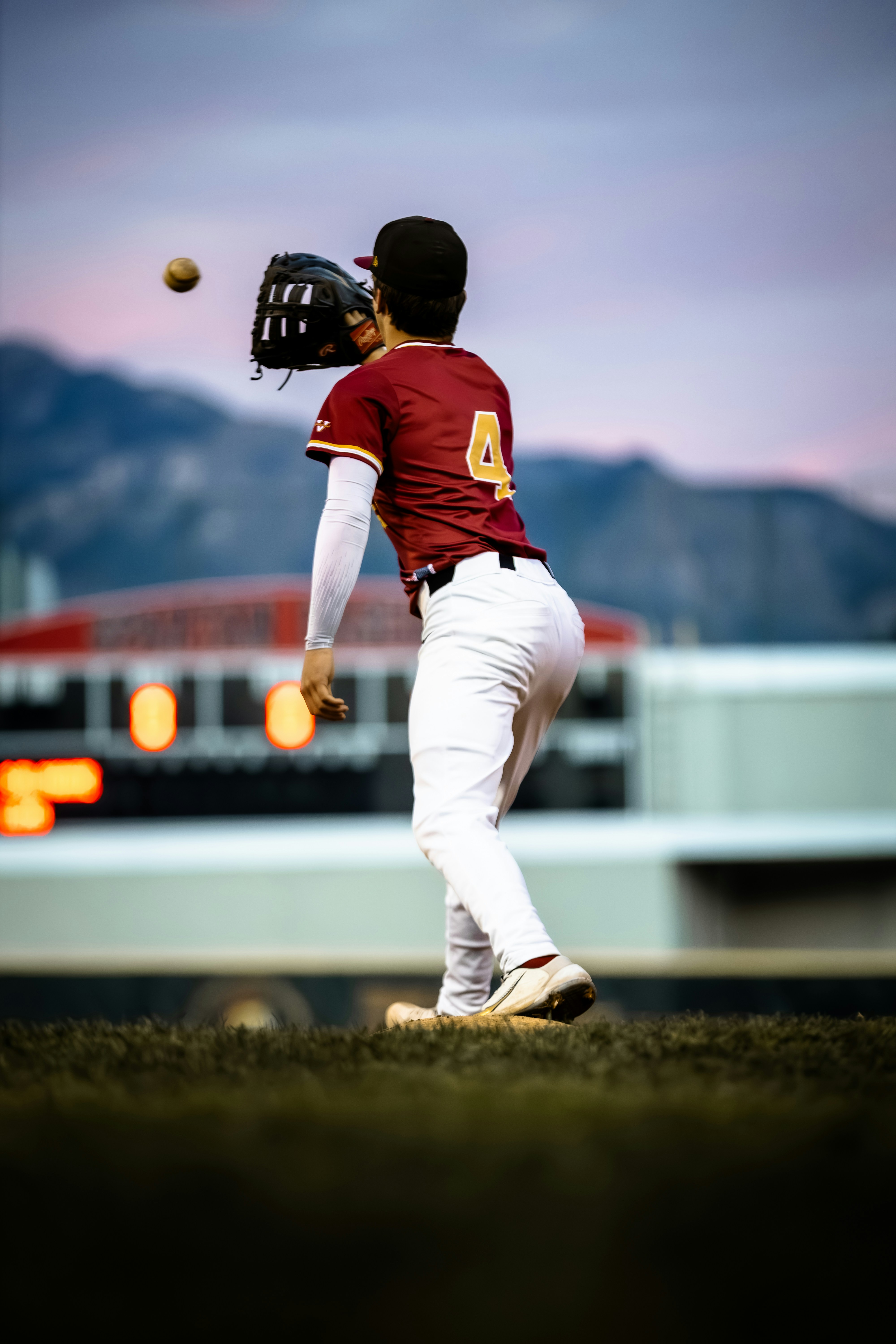 Baseball player catching a ball at dusk