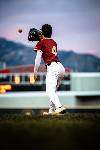 Baseball player catching a ball at dusk