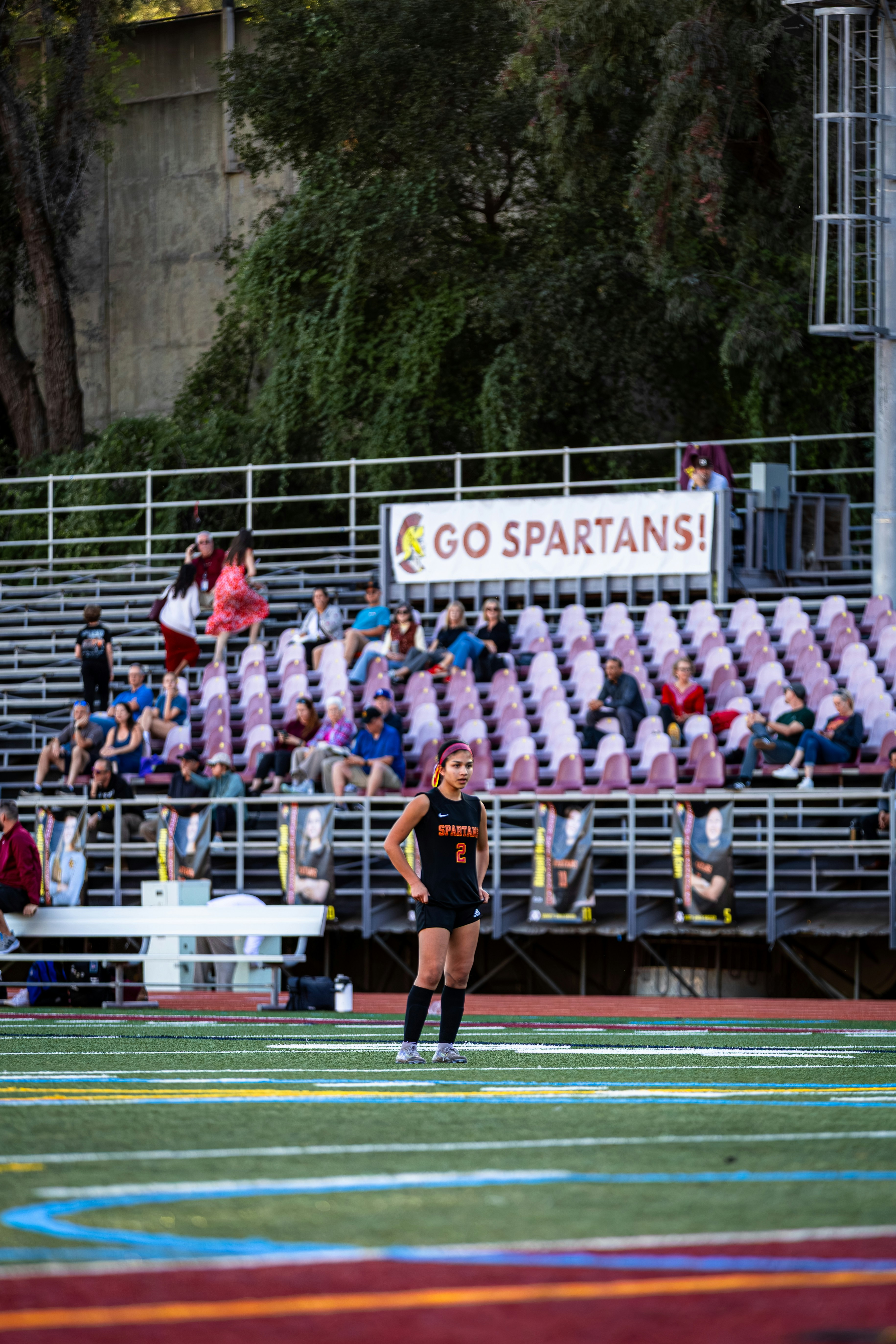 Young athlete on a sports field with spectators.