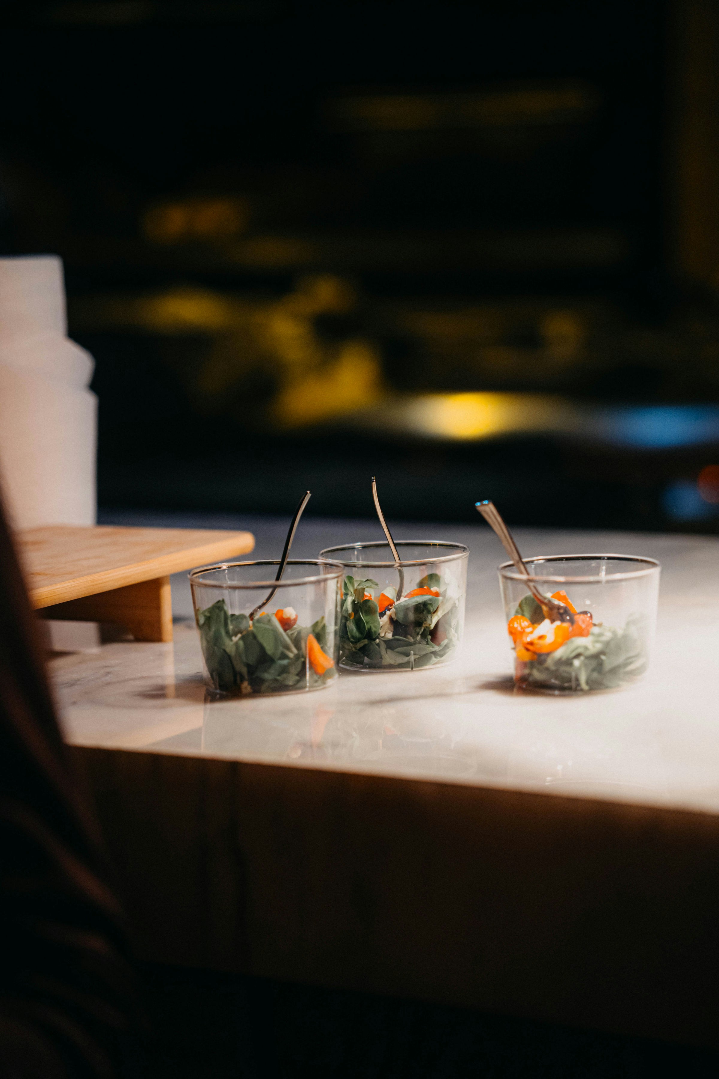 Drei kleine, durchsichtige Becher mit Essen und Gabeln