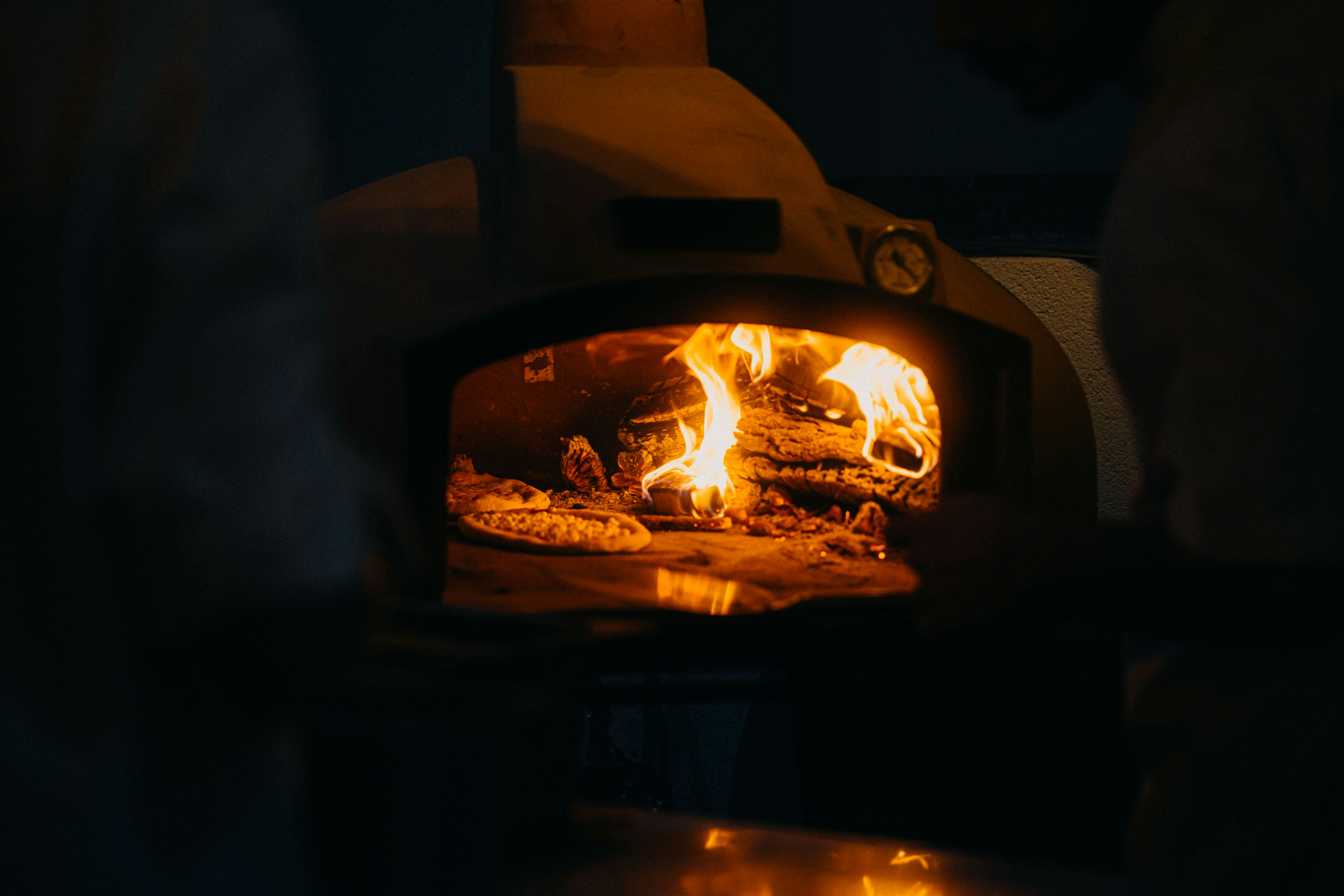 Pizza backt in einem Holzofen mit glühenden Glut