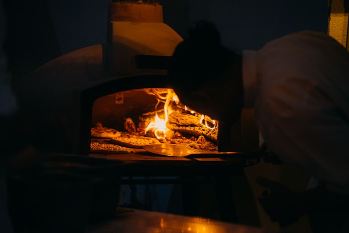 Wood-fired dome pizza oven with efficient combustion and glowing embers