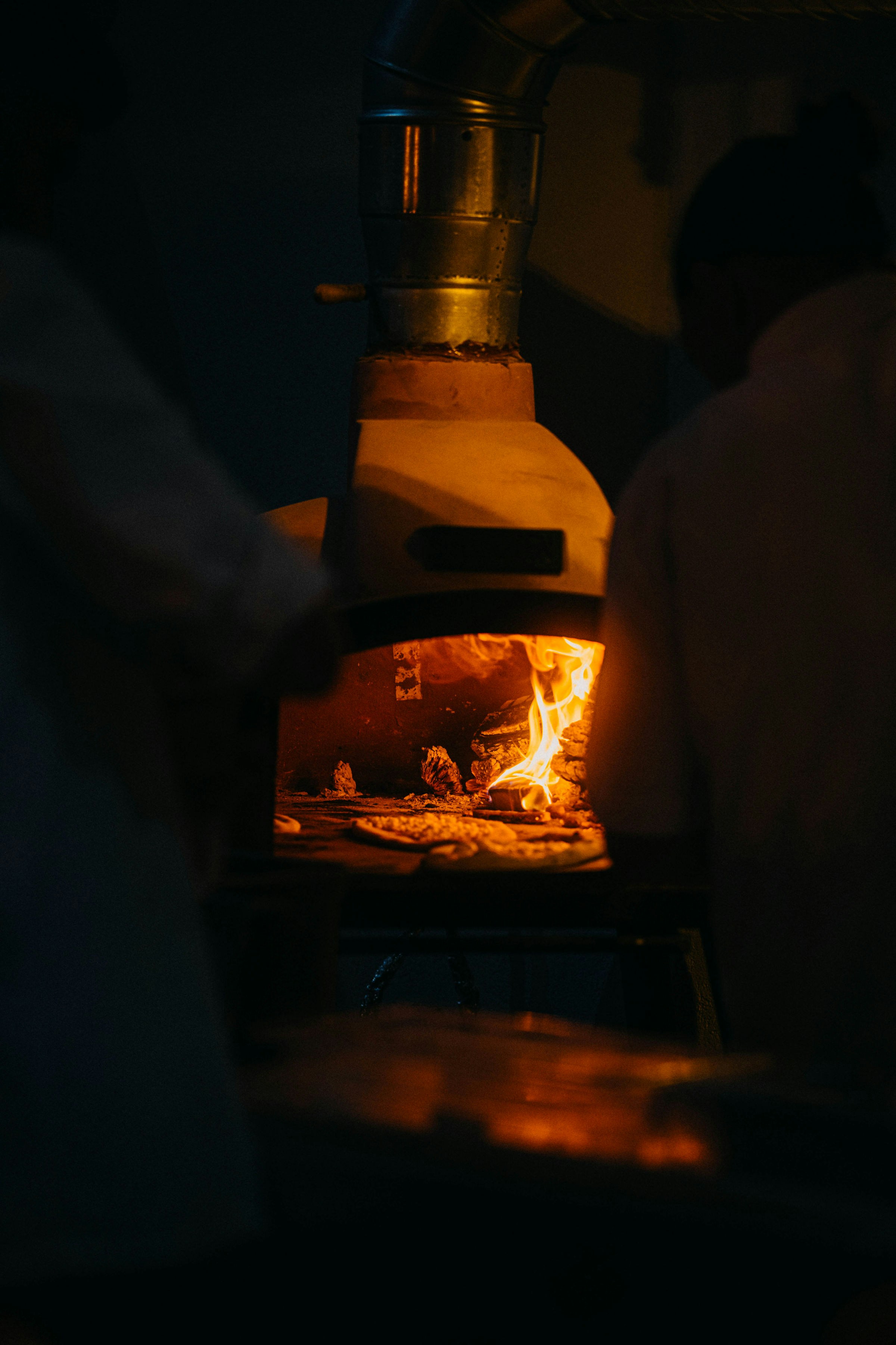 Pizza cuite au feu de bois sortant du four