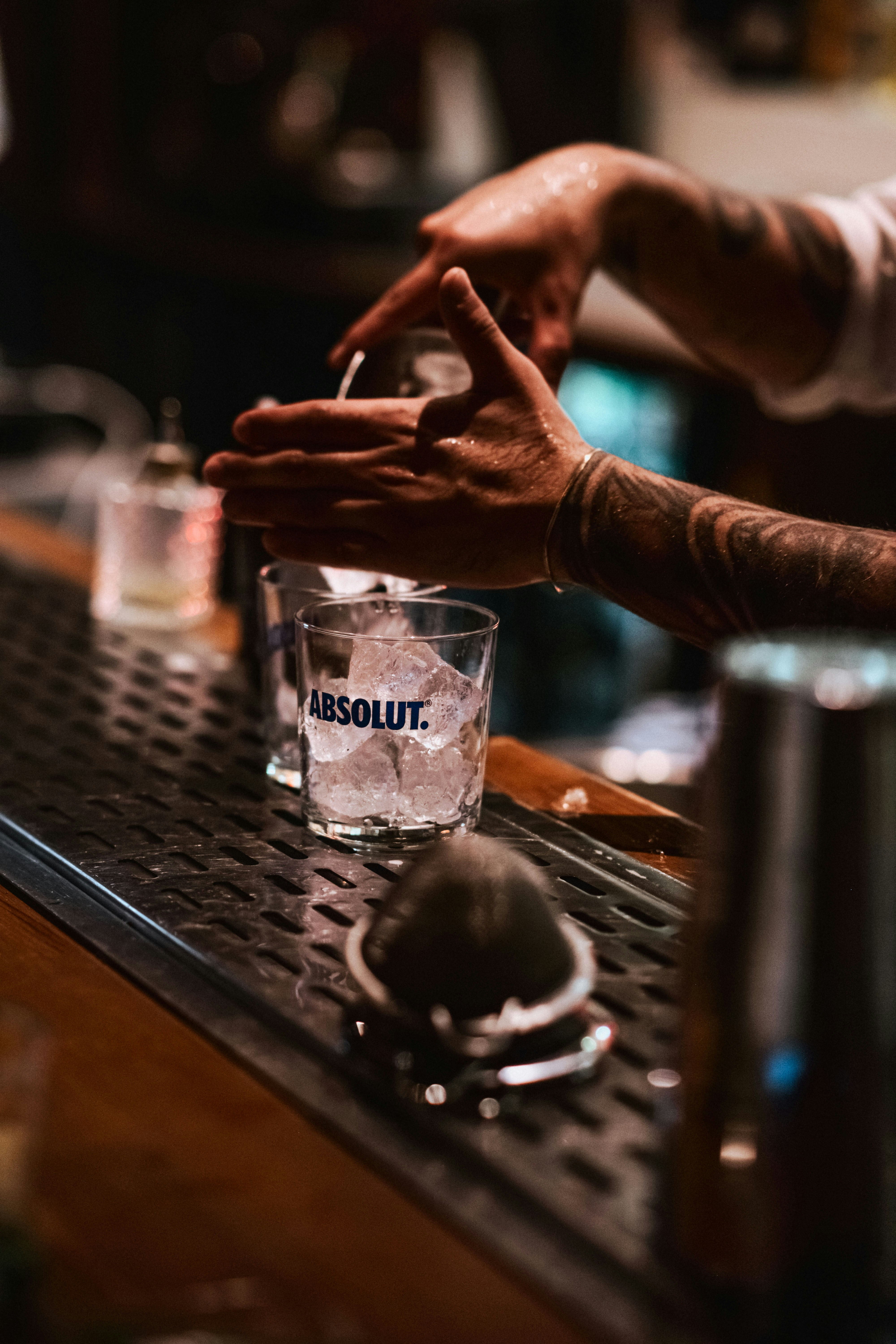 Bartender preparing a drink with ice in glass