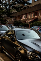 A black luxury car parked on a city street.