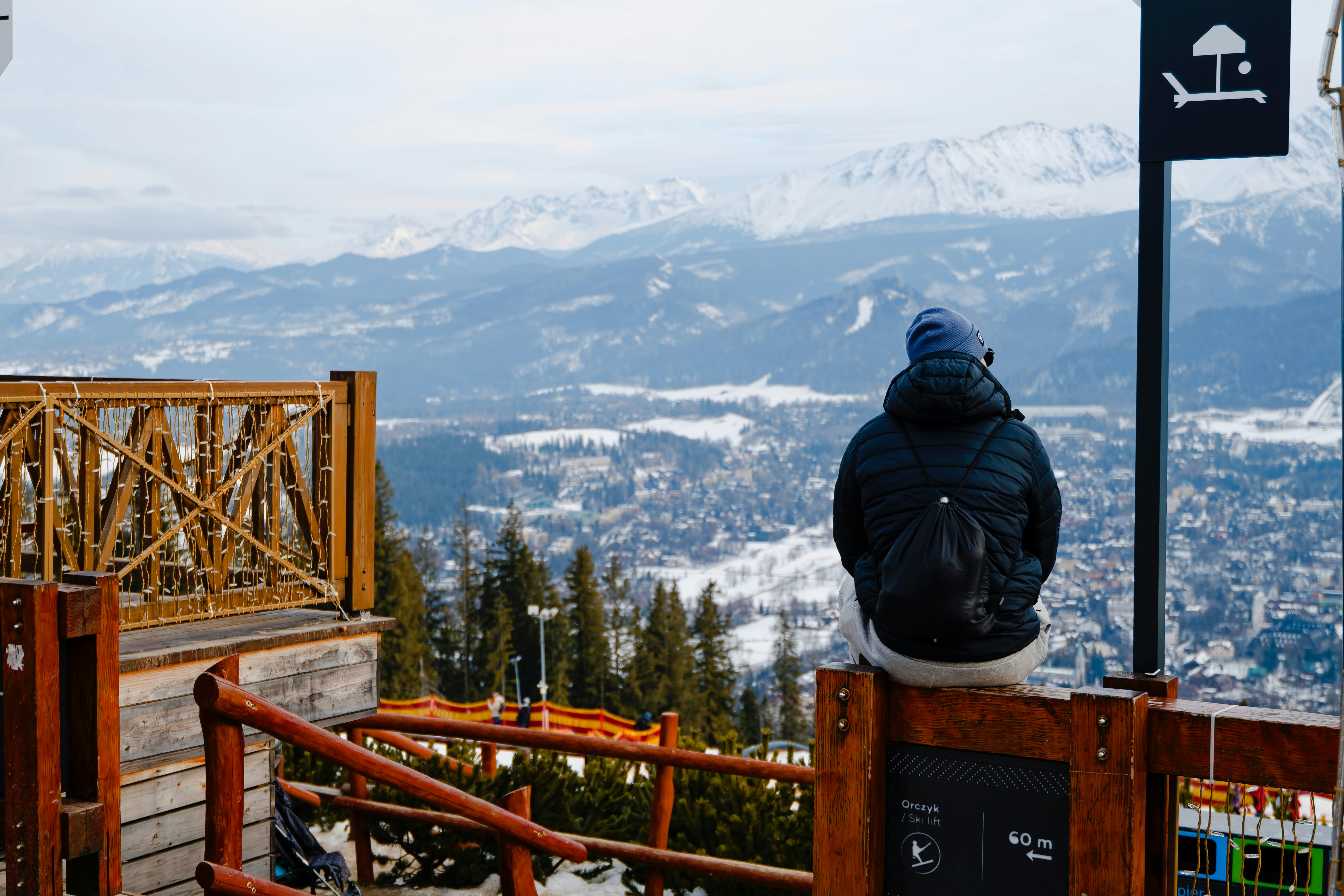 Person, die die verschneite Berglandschaft aus dem Blickwinkel betrachtet.