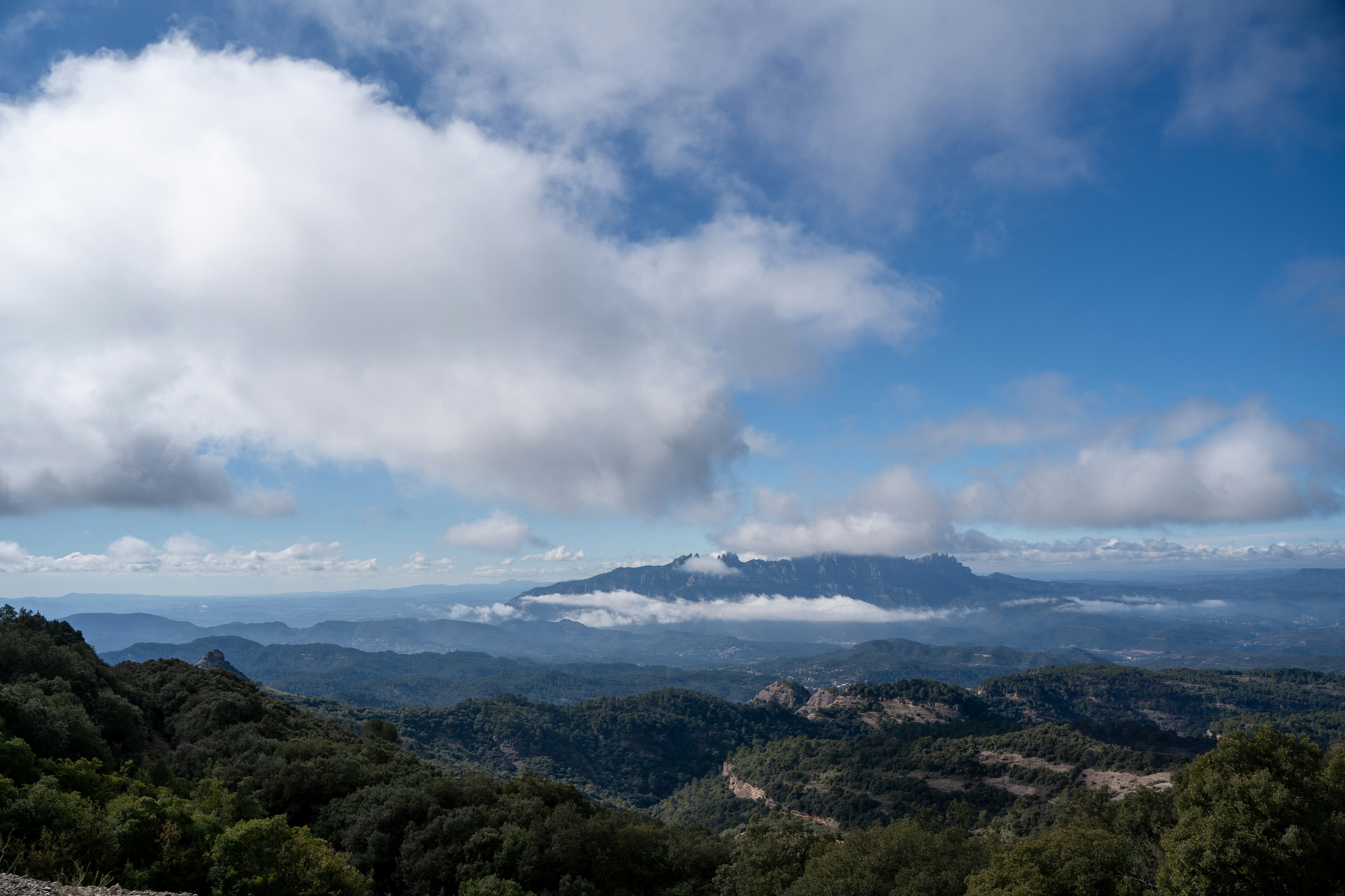 Hazy mountains under a cloudy blue sky