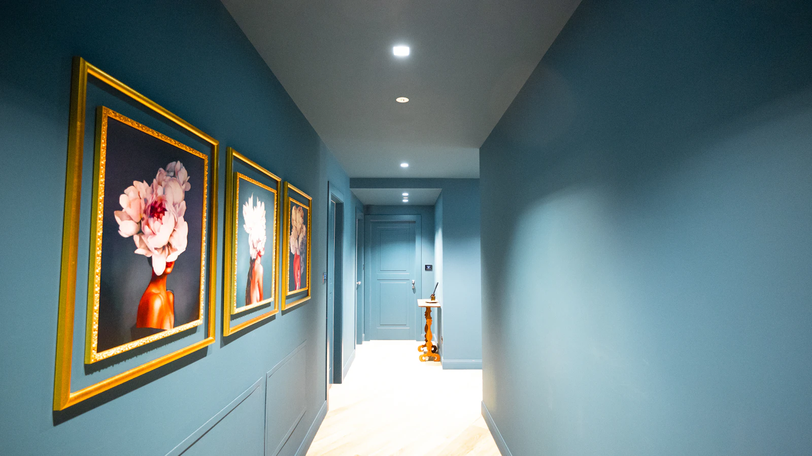 Freshly painted teal hallway with panelling and framed artwork