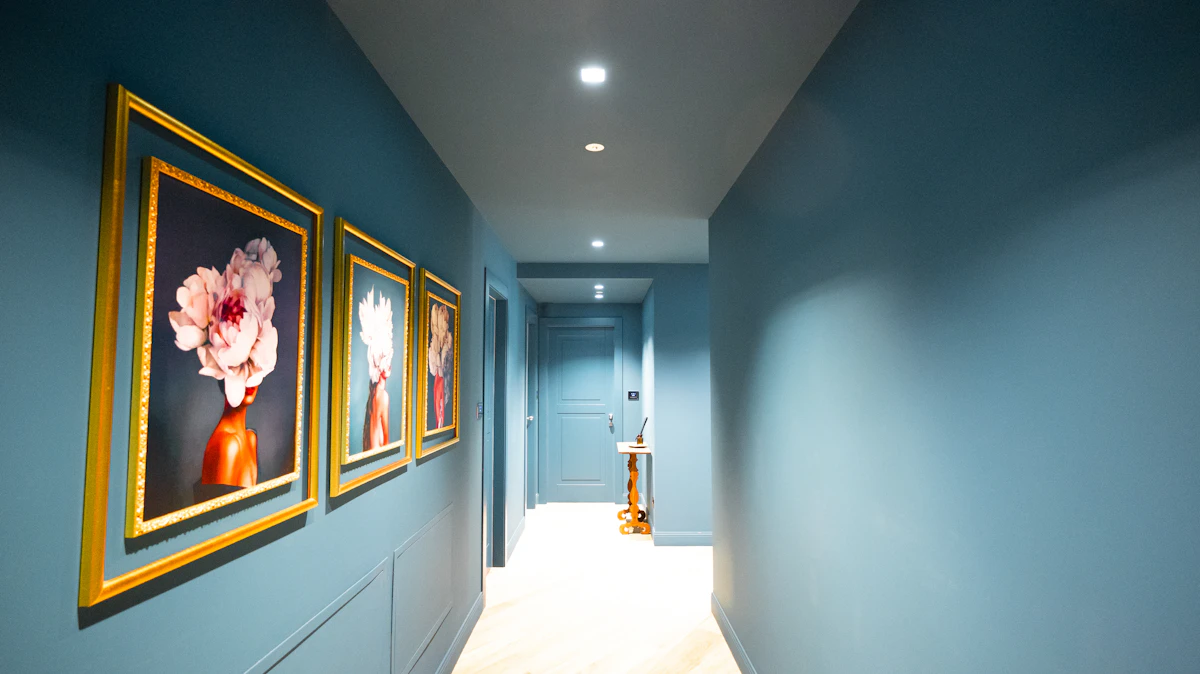 Corredor com parede pintada de azul vibrante e quadros na parede